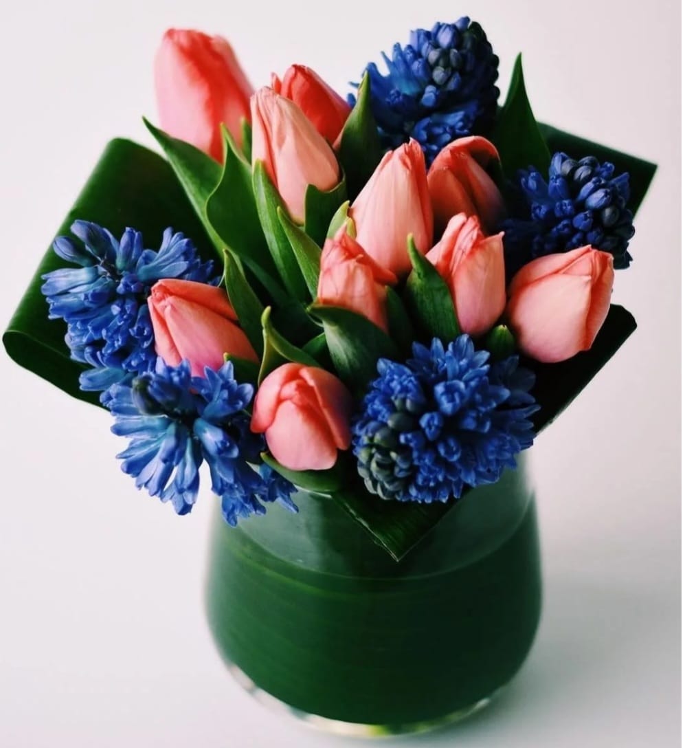 Bold and Beautiful  - A mix of tulips and fragrant hyacinths complemented with tropical leafs around  the vase