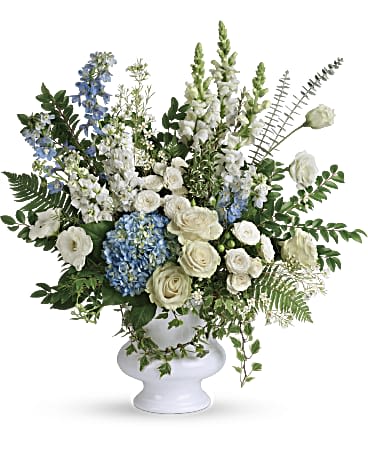 Treasured And Beloved Bouquet  - A treasured tribute to your beloved, this gorgeously grand bouquet of soft blue hydrangea and pure white roses is reminiscent of a clear sky, a hopeful reminder of life and love. This beautiful bouquet of light blue hydrangea, white roses, white spray roses, white lisianthus, light blue delphinium, white snapdragons, white stock, and white waxflower is accented with huckleberry, variegated ivy, spiral eucalyptus, dagger fern, and lemon leaf. Delivered in a white designer urn. Approximately 29" W x 30" H