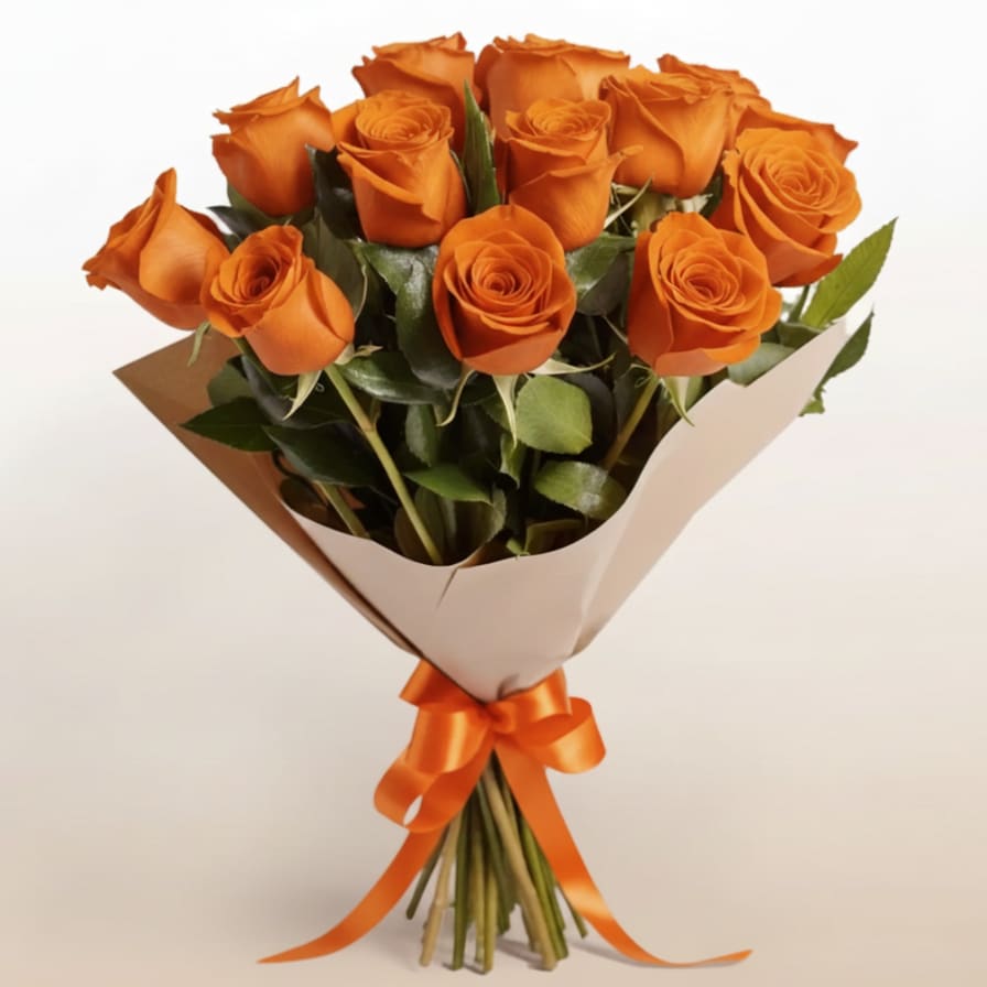 12 Orange Roses Bouquet - Twelve vibrant orange roses bursting with energy and enthusiasm. This bold bouquet conveys admiration, excitement, and creativity—an excellent choice for congratulations, celebrations, or uplifting moments.  Note: The tone of the rose colors, wrapping paper, and filler flowers may vary slightly depending on seasonal availability and inventory.