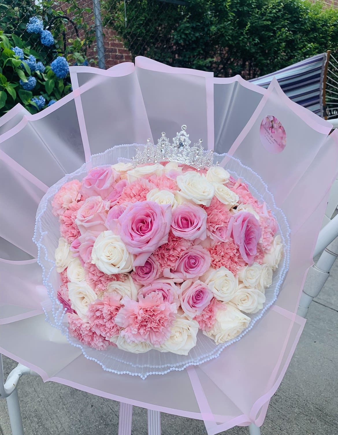 Princess Ramo  - A bouquet of pink and white roses, accented with light pink carnations. Perfect for birthday, anniversaries, I love you, or I'm sorry. Tiara not included. (Approximately 60 stems)