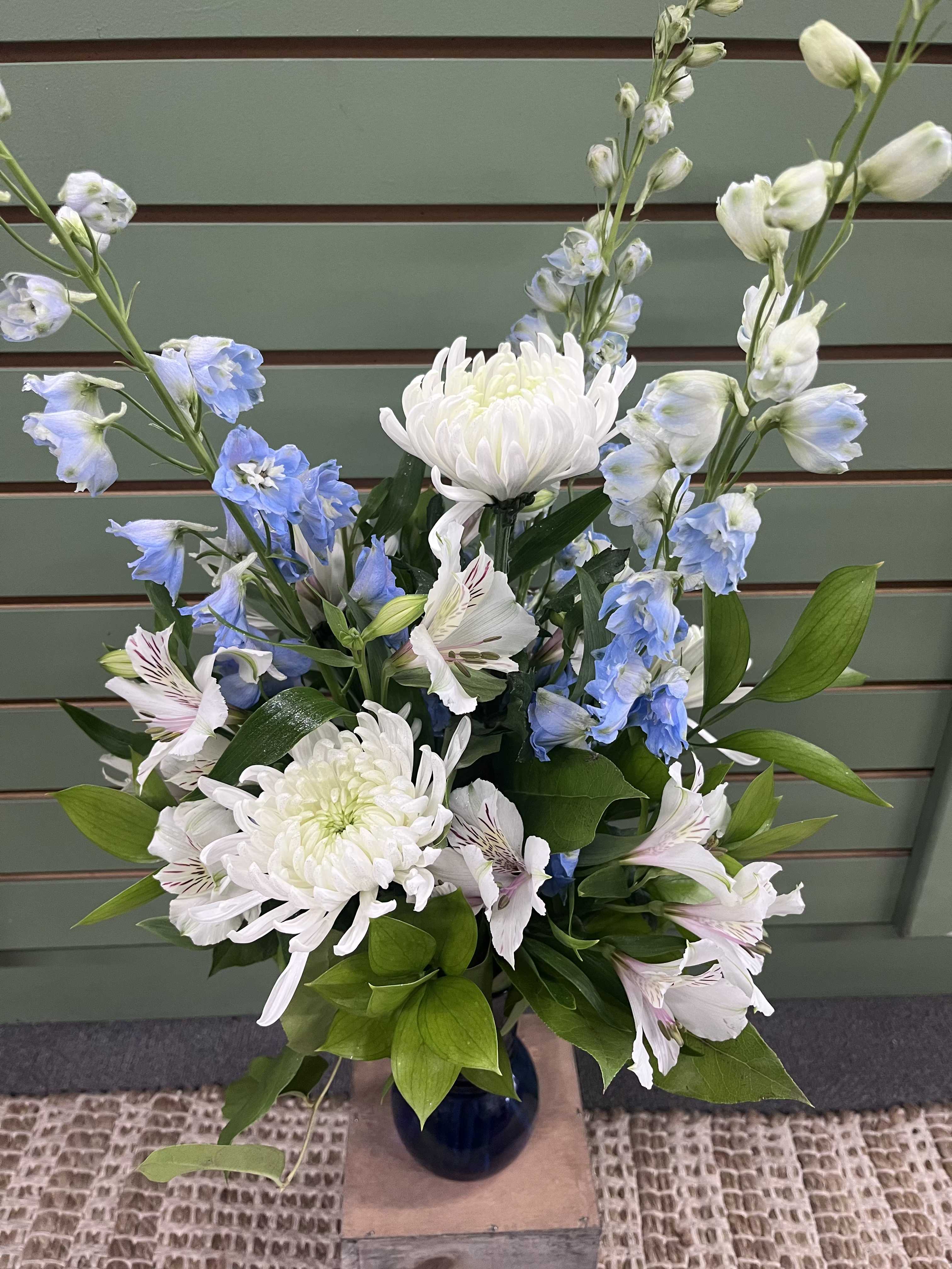 Winter Wonderland  - Embrace the winter wonderland of Minnesota with flowers! Get yourself or someone you care about this beautiful wintery arrangement! Winter Wonderland features white alstroemeria, white spider mums, and blue delphinium in a blue vase. 