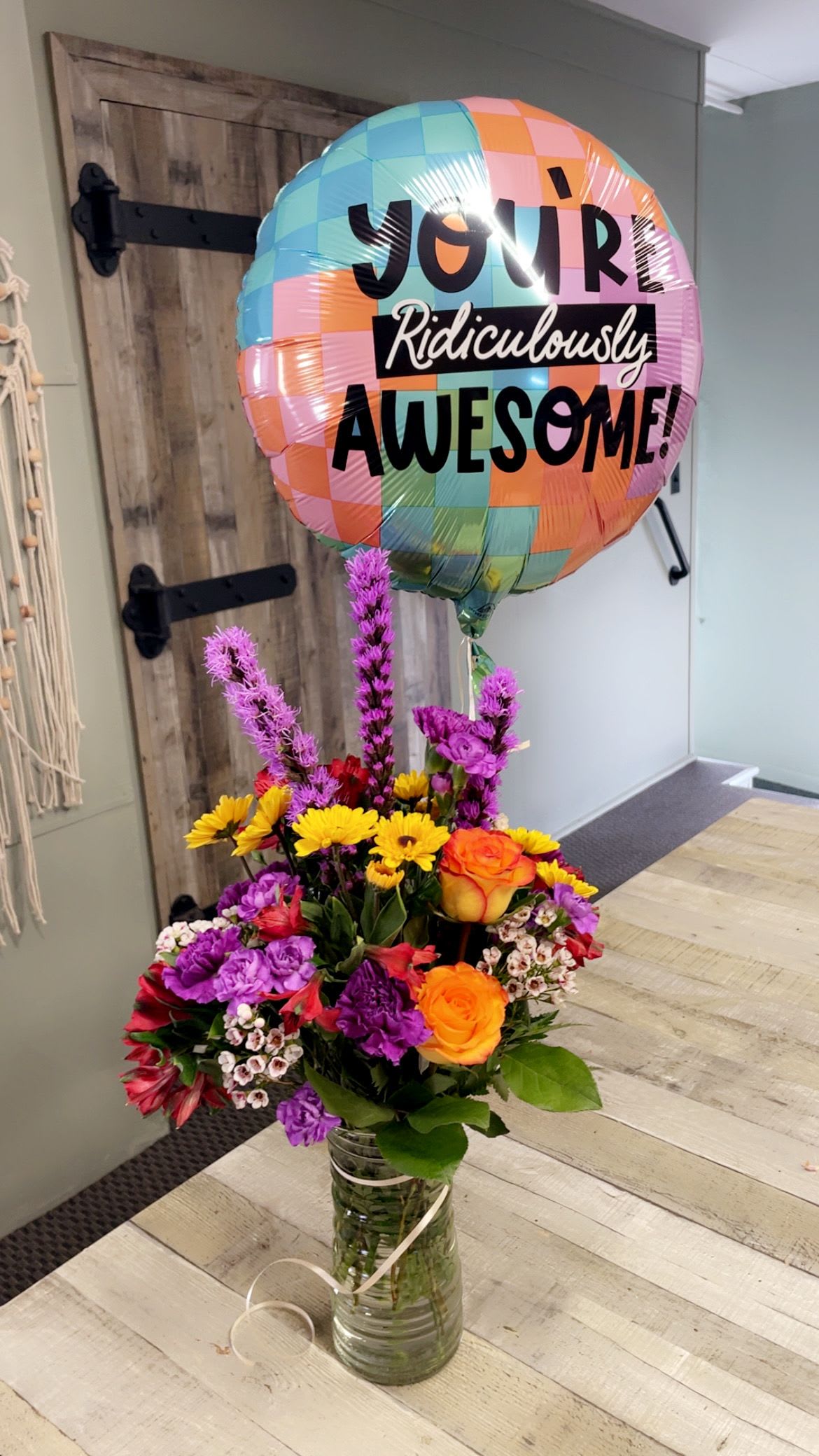 Ridiculously Awesome  - You know what is ridiculously awesome? You. A  clear glass vase with a Mylar balloon. The colors and kinds of flowers will be designers choice. We will pick out the freshest and best blooms available at the time for the person in your life who is a big deal.The design is all the way around.   