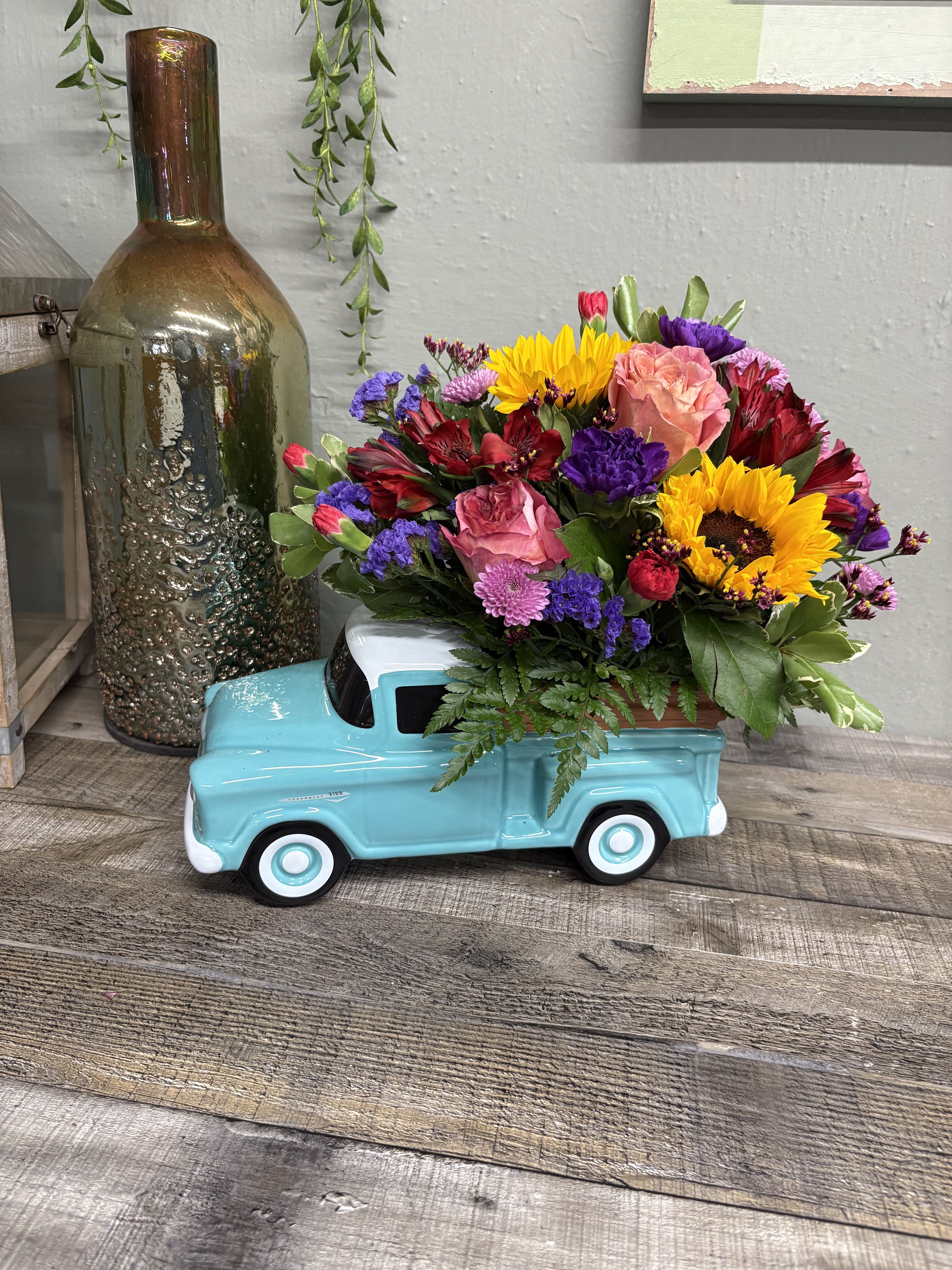 Teleflora’s Chevy Pick up - Beep beep! They're sure to love this colorful bouquet riding in the back of a classic Chevy pickup. This hand-painted, hand-glazed ceramic design is a cool keepsake they'll treasure forever! This bouquet includes a colorful mix with roses, mums and other colorful blooms.  We will choose the freshest blooms available. Delivered in Teleflora's Chevy Pickup Keepsake. Orientation: All-Around