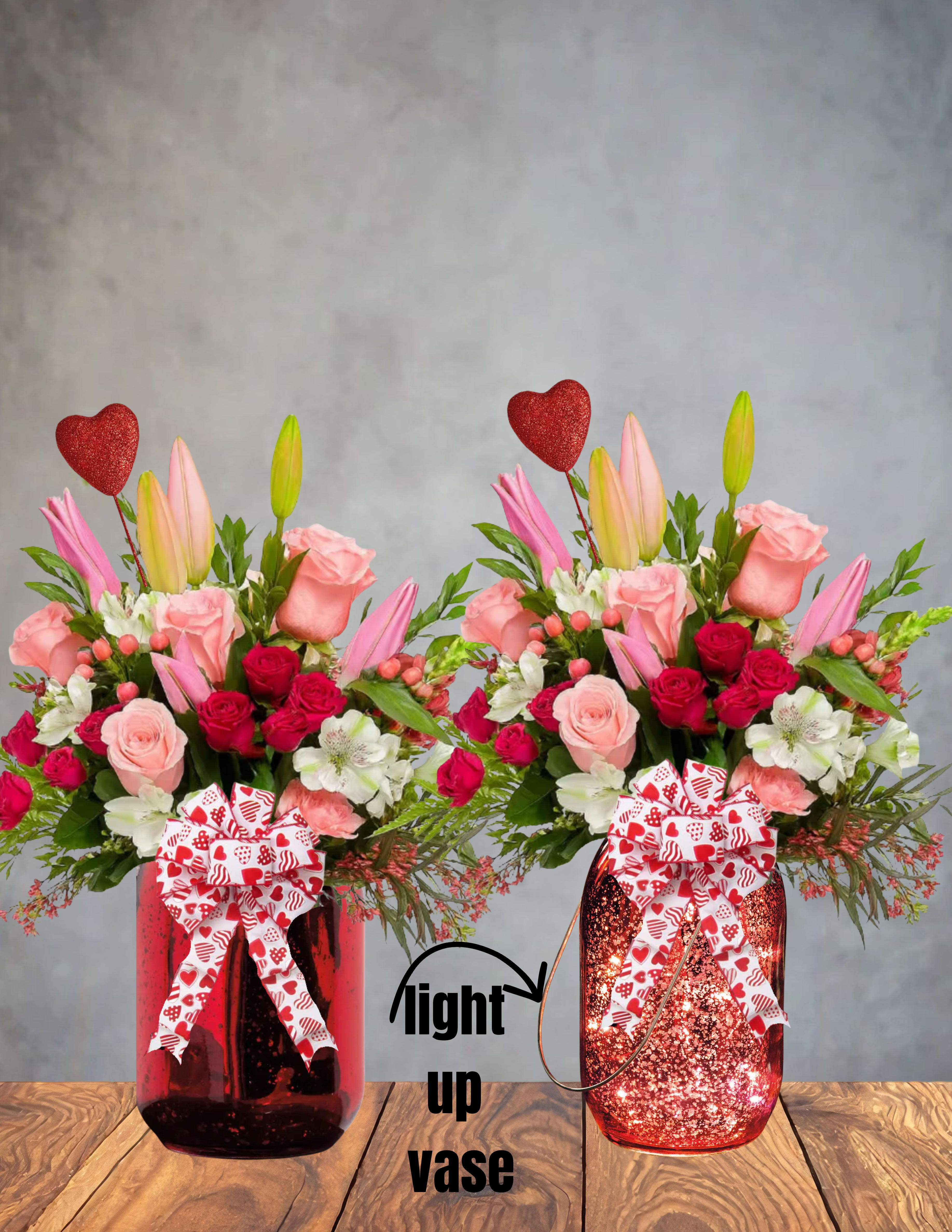 Blushing Hearts   -  Blushing Hearts   Soft romance meets striking style in this vibrant, full‑of‑feeling arrangement. Blushing Hearts features lush pink roses and vivid hot‑pink spray roses, paired with playful pops of hypericum and the delicate texture of wax flower. Elegant alstroemeria adds movement and charm, while the star of the show—fragrant pink stargazer lilies—brings drama, color, and irresistible sweetness.  Designed in a bold red spiky vase, this bouquet blends tenderness with attitude, making it perfect for anyone who loves their flowers with a little flair. Whether it’s a romantic gesture, a celebration, or a just‑because moment, Blushing Hearts delivers beauty with confidence.