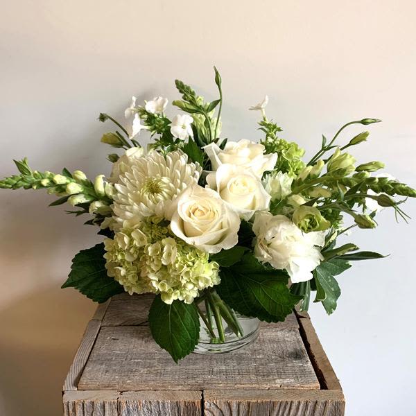 Adagio  - A classic combination of white and green, this elegant arrangement consists of seasonal flowers in a neutral color palette designed in a clear cylinder vase.  PLEASE NOTE: While we try our best to use all the flowers pictured, flower varieties will vary due to availability. Our designers always select the freshest blooms for your arrangement.   Deluxe version is pictured
