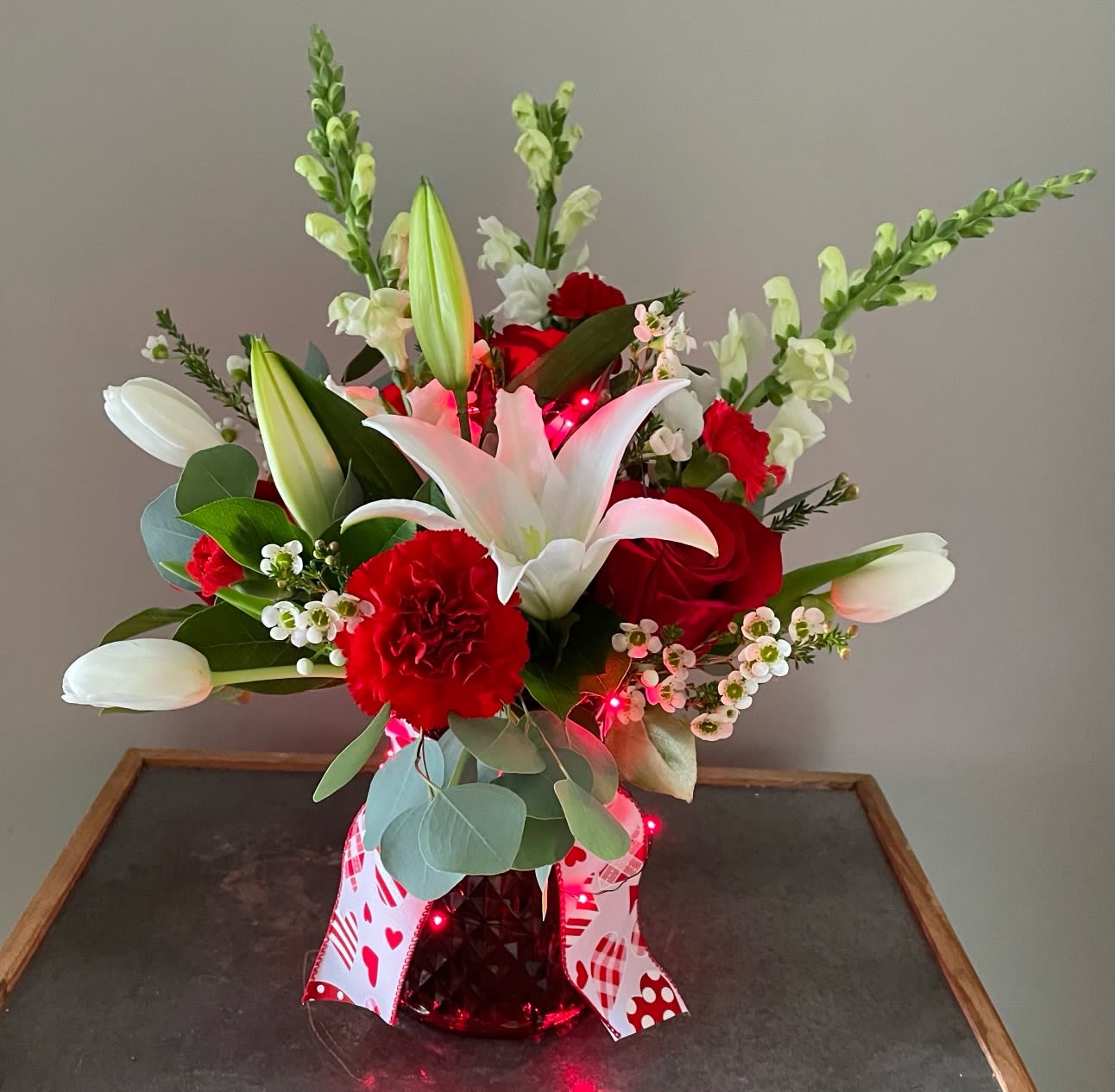Turn Me On Valentine - Send something that will light up their day...this arrangement is delivered in a ruby red vase that is accented with lights on the outside and through out the arrangement. The vibrant flowers include roses, carnations, tulips and lilies. This is the perfect romantic bouquet that is sure to brighten this occasion!  Flowers are guaranteed for 24 hours after delivery. 