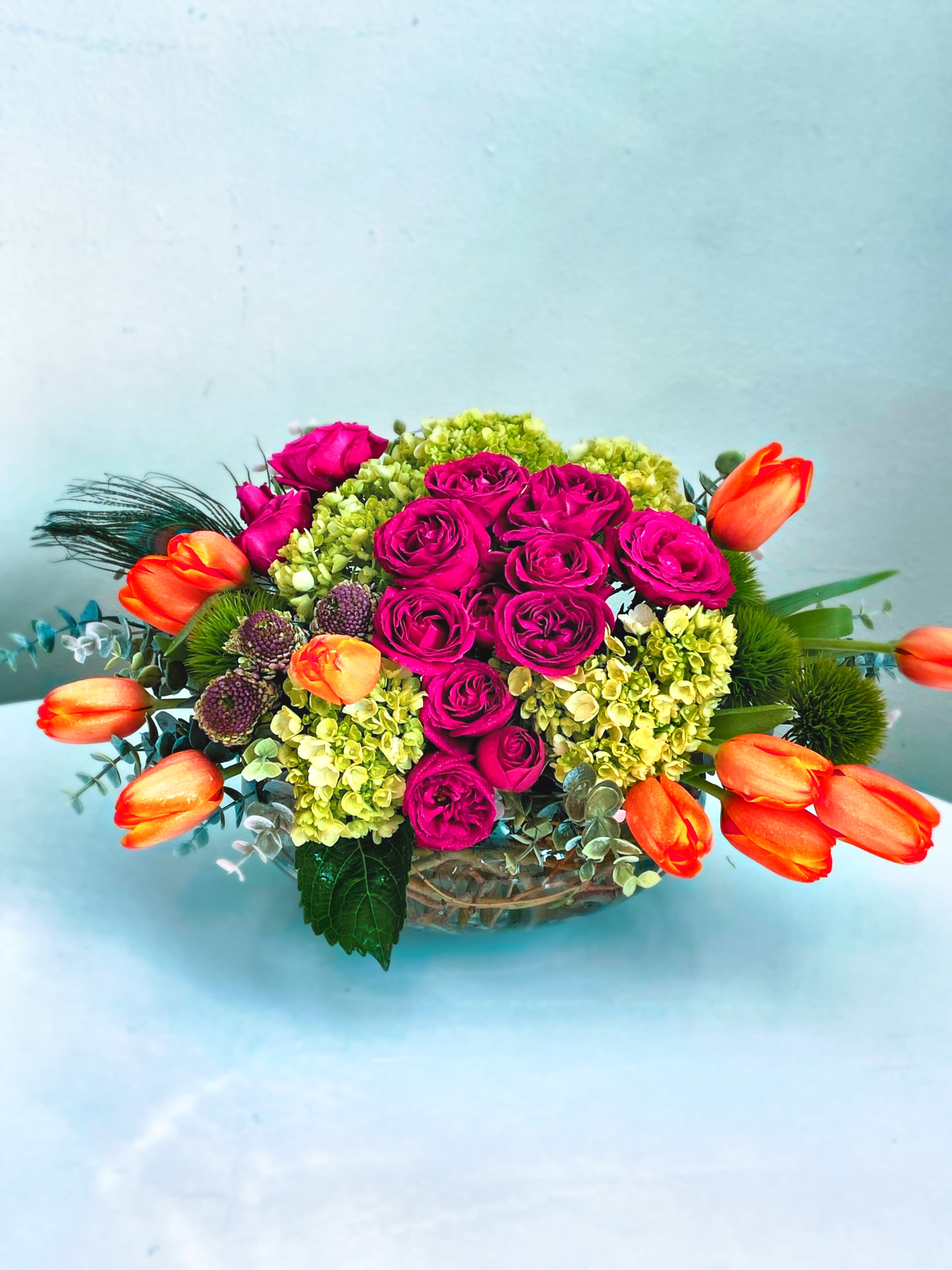 Vibrant bowl - This is a vibrant green, hot pink and orange arrangement. It’s about 18 wide and 8 in tall. Orange, green dianthus, green hydrangea, hot pink spray roses and a touch of purple. Gorgeous lush and happy.