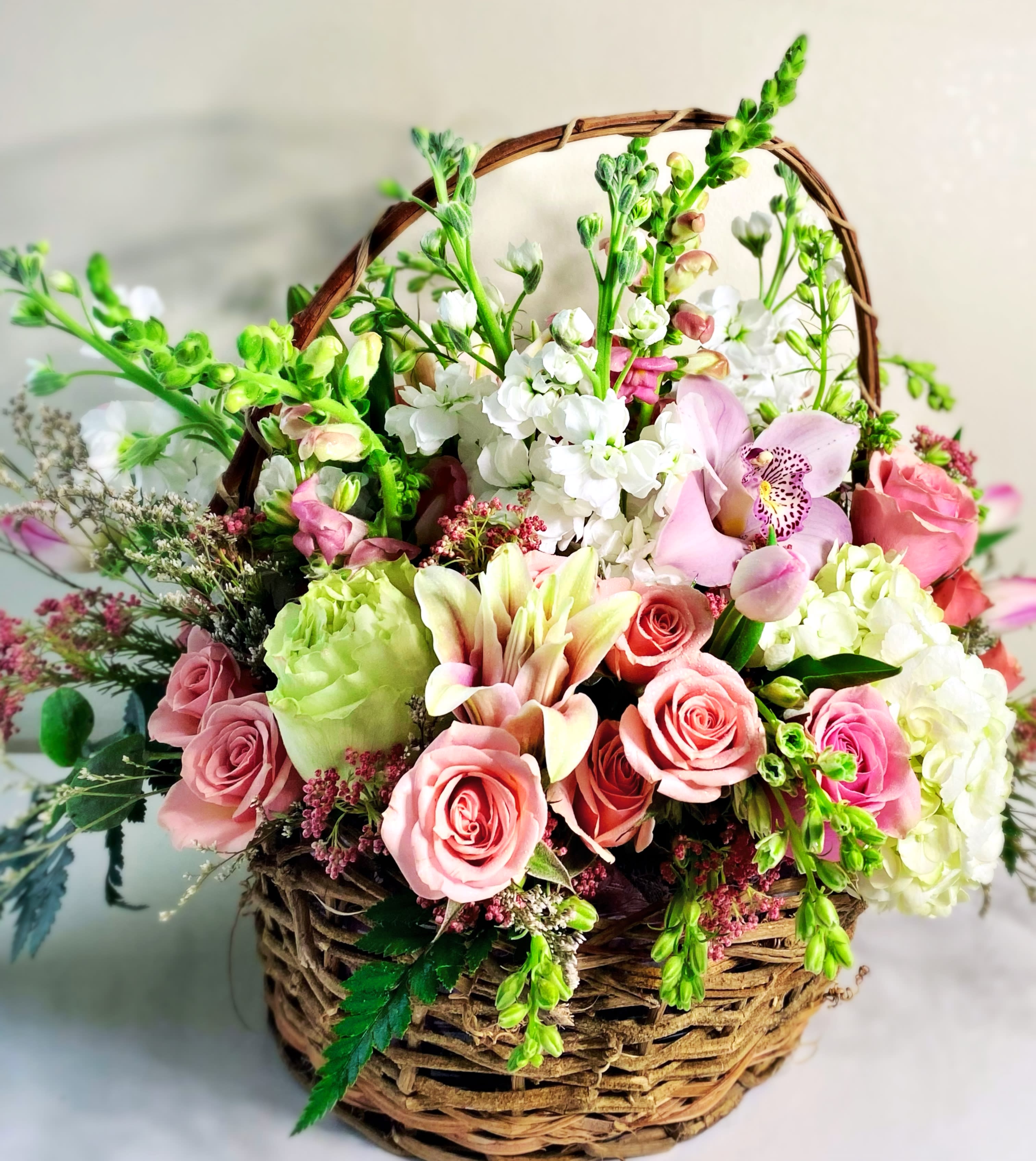 Spring basket blooms - Darling Spring basket is a floral shape of pinks, white and a touch of green. Gift this floral basket for a birthday , get well, Mother’s Day,or sympathy arrangement. This is a fairly big basket. Approximately size is 22x18 in. 