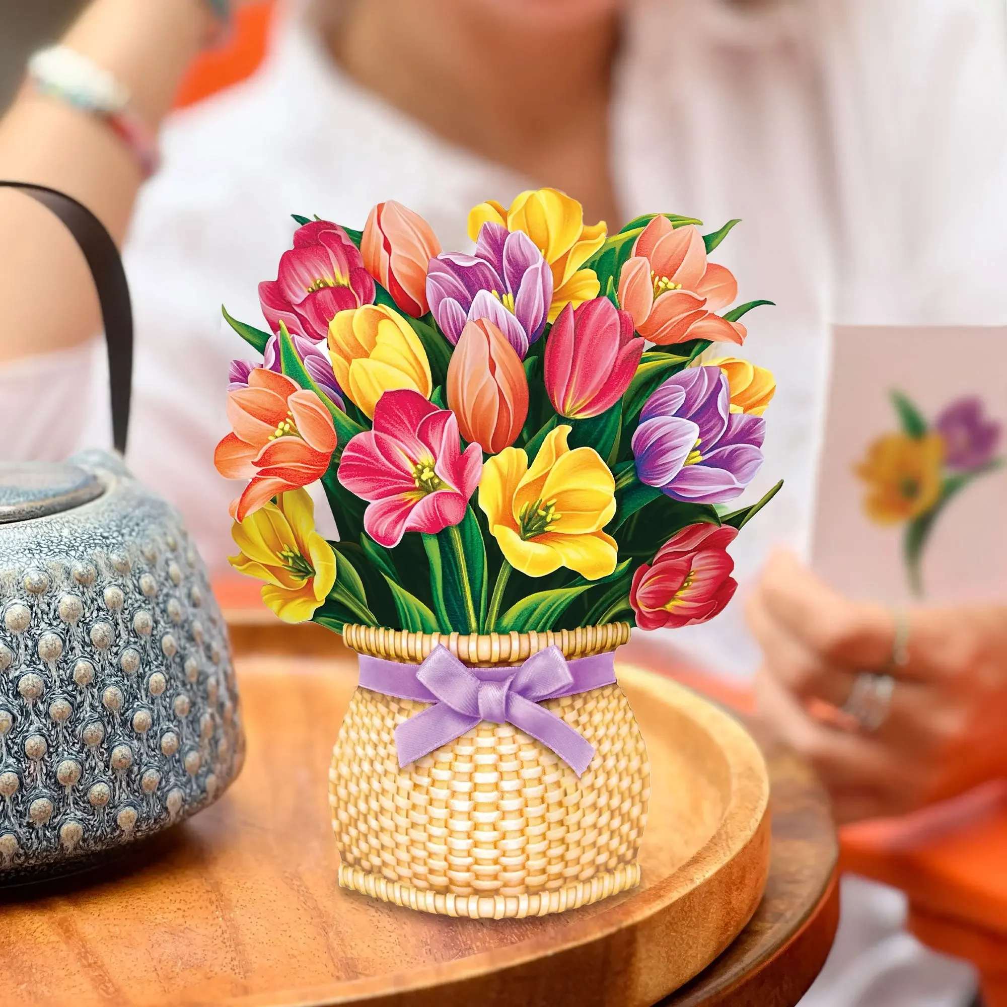 Mini Festive Tulips Pop-Up Card - The muse of many Dutch artists now blooms in a marvelously mini size. FreshCut Paper’s Mini Festive Tulips Bouquet features a dazzling collection of sustainable, vibrant blooms that radiate the essence of spring long after the season ends. For gifts on the go and special somethings to commemorate unconditional love, your family and friends will always remember how much you care as they unbox the delight of tulips.  Measures approx 5.5” high by 5" across