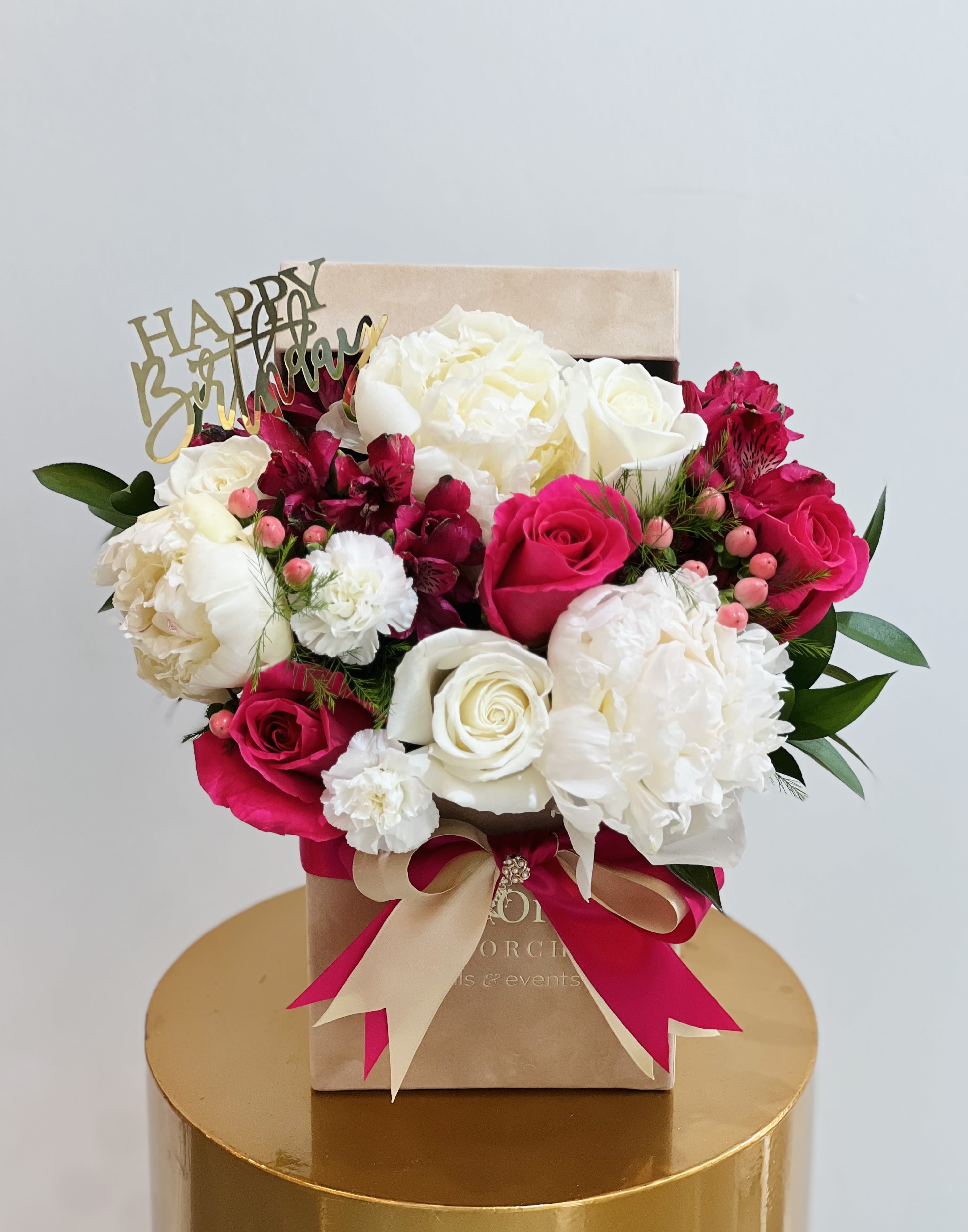 Sweet Elegance ™ - A lush arrangement of creamy white peonies, classic ivory roses, and vibrant fuchsia blooms, artfully styled in a keepsake box and finished with a satin ribbon. This design balances softness and bold color, creating a joyful yet elegant statement perfect for birthdays, anniversaries, and unforgettable moments. Every detail is thoughtfully placed to express love, celebration, and refined beauty.