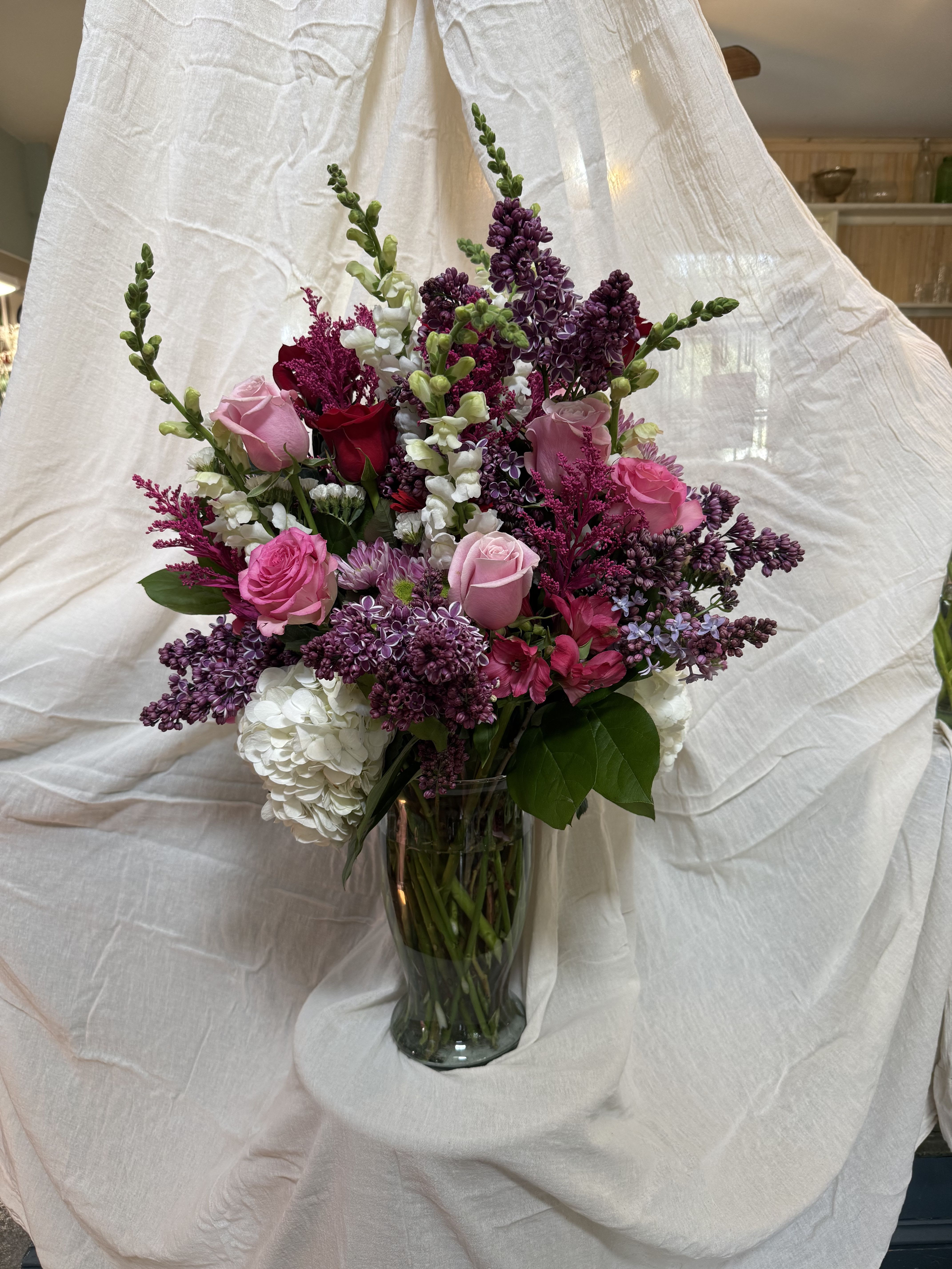 Botanical Dream Bouquet - An arrangement of roses, snap dragons, lilacs, hydrangeas, statice, alstroemeria, aster, and greens. Any of these flowers can be swapped for something asked for in advance. 