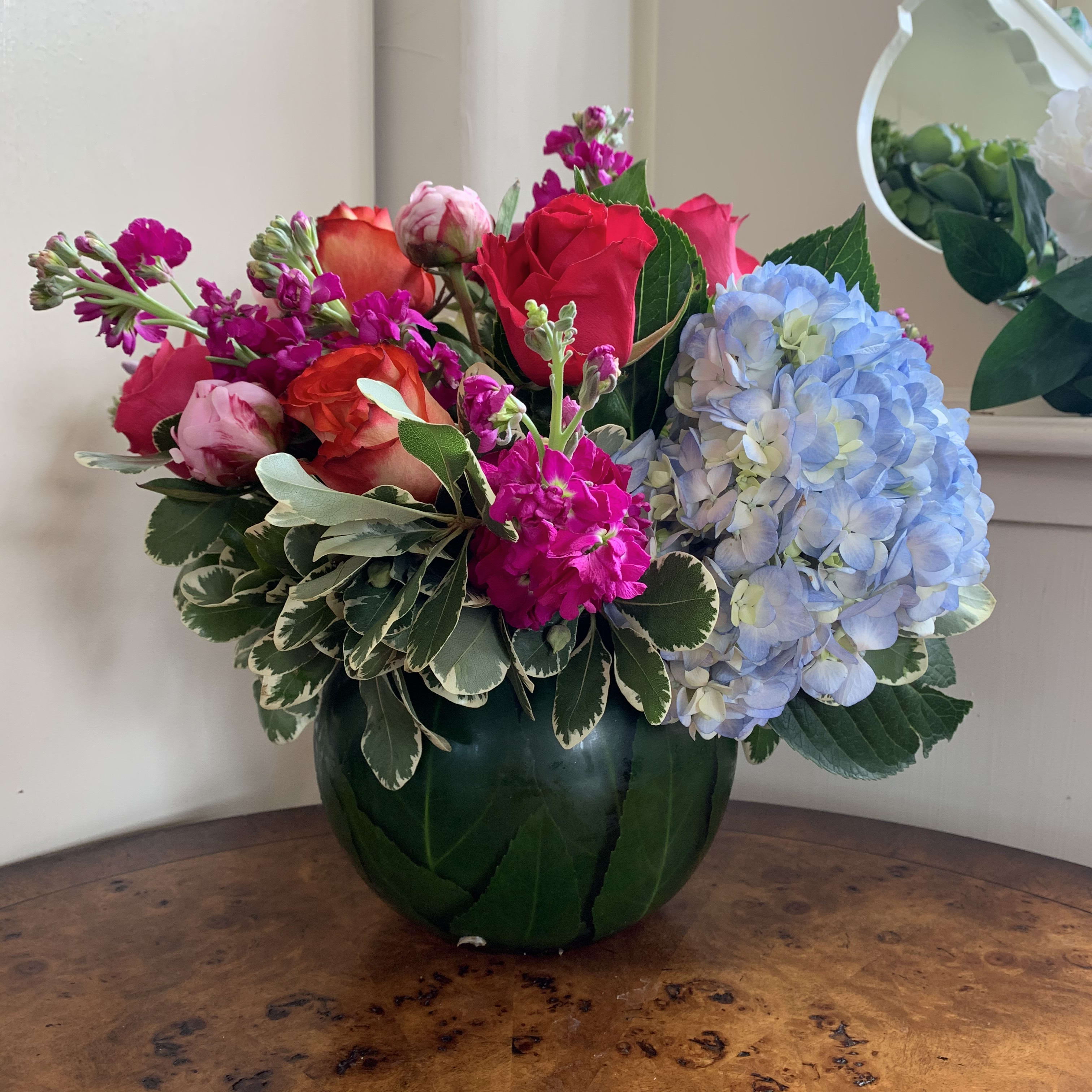 Garden Jubilee - Blue hydrangea, hot pink and orange roses, magenta stock, and pink peonies arranged in a large 8in leaf lined bubble bowl. approximatly 12in tall and 12in wide. 