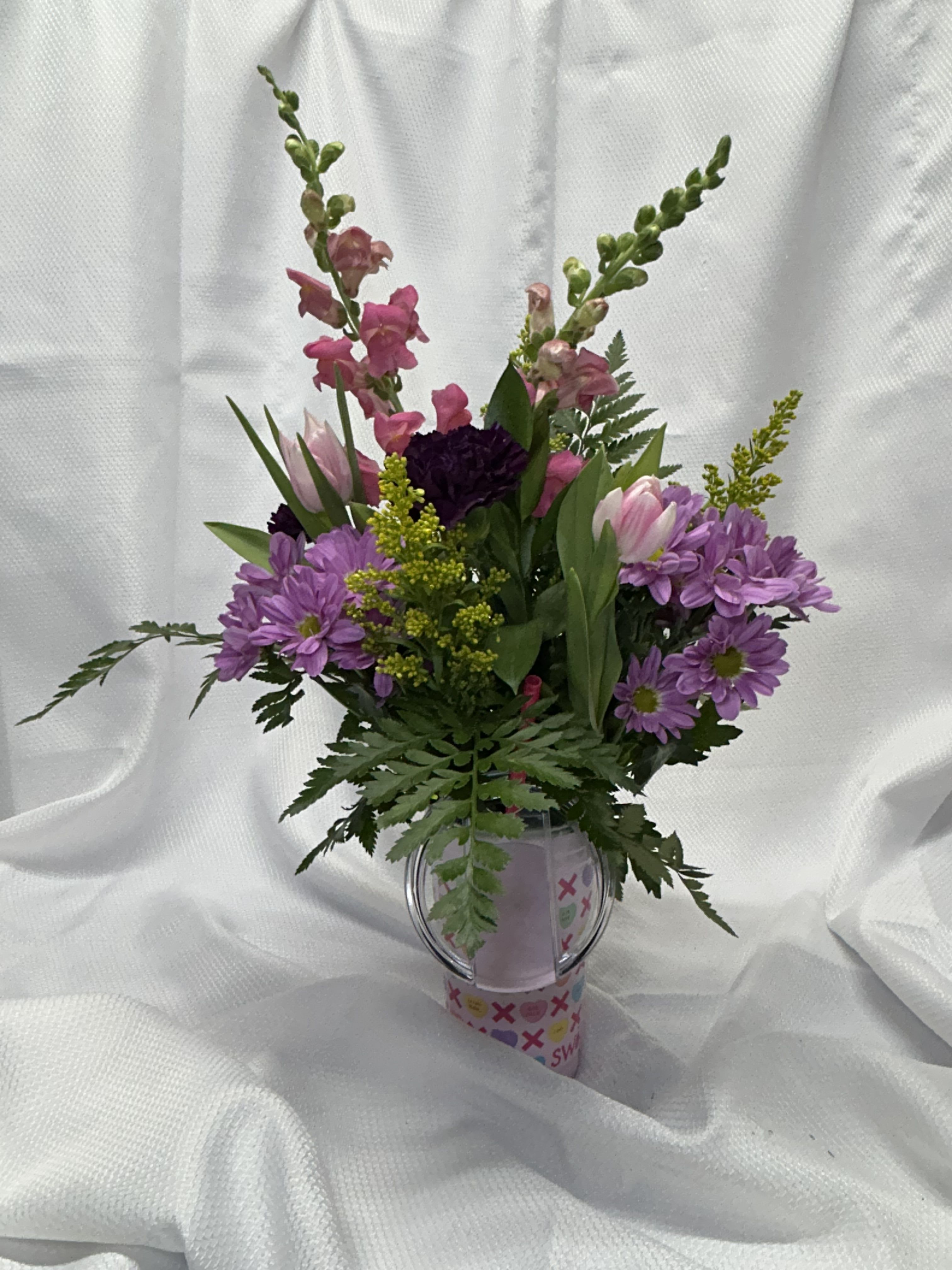 Cutie Pie - Pink snapdragon, lavender daisy, pink tulips, purple carnations, &amp; solidego in a swig cup. Cups are dishwasher safe.