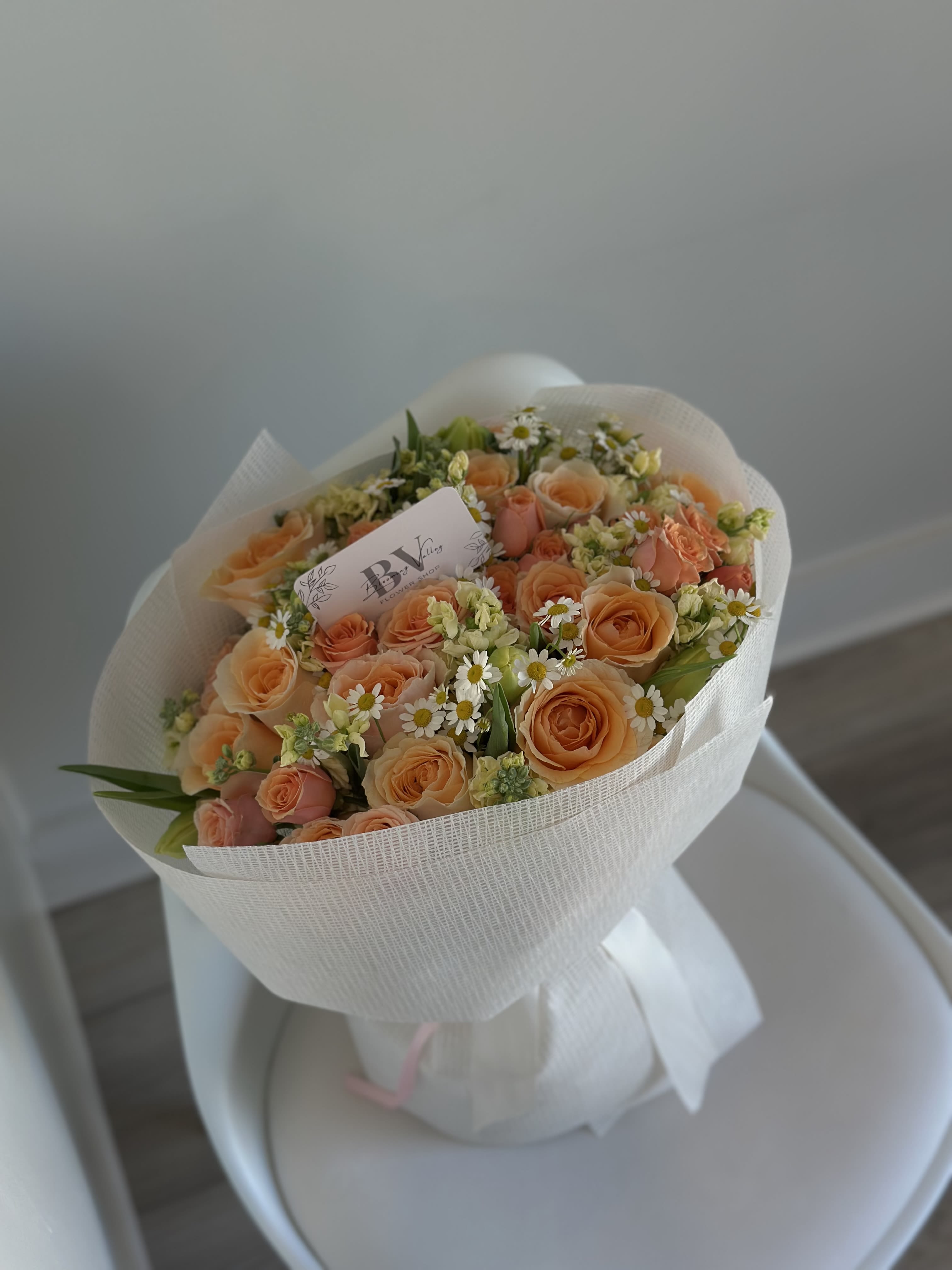 Citrus Charm - A bright and cheerful mix of tangerine and peach roses, playful chamomile, and soft seasonal greens. This bouquet is a burst of joy and warmth — like sunshine in floral form. Perfect for celebrations, thank-yous, or just to say you light up my day.