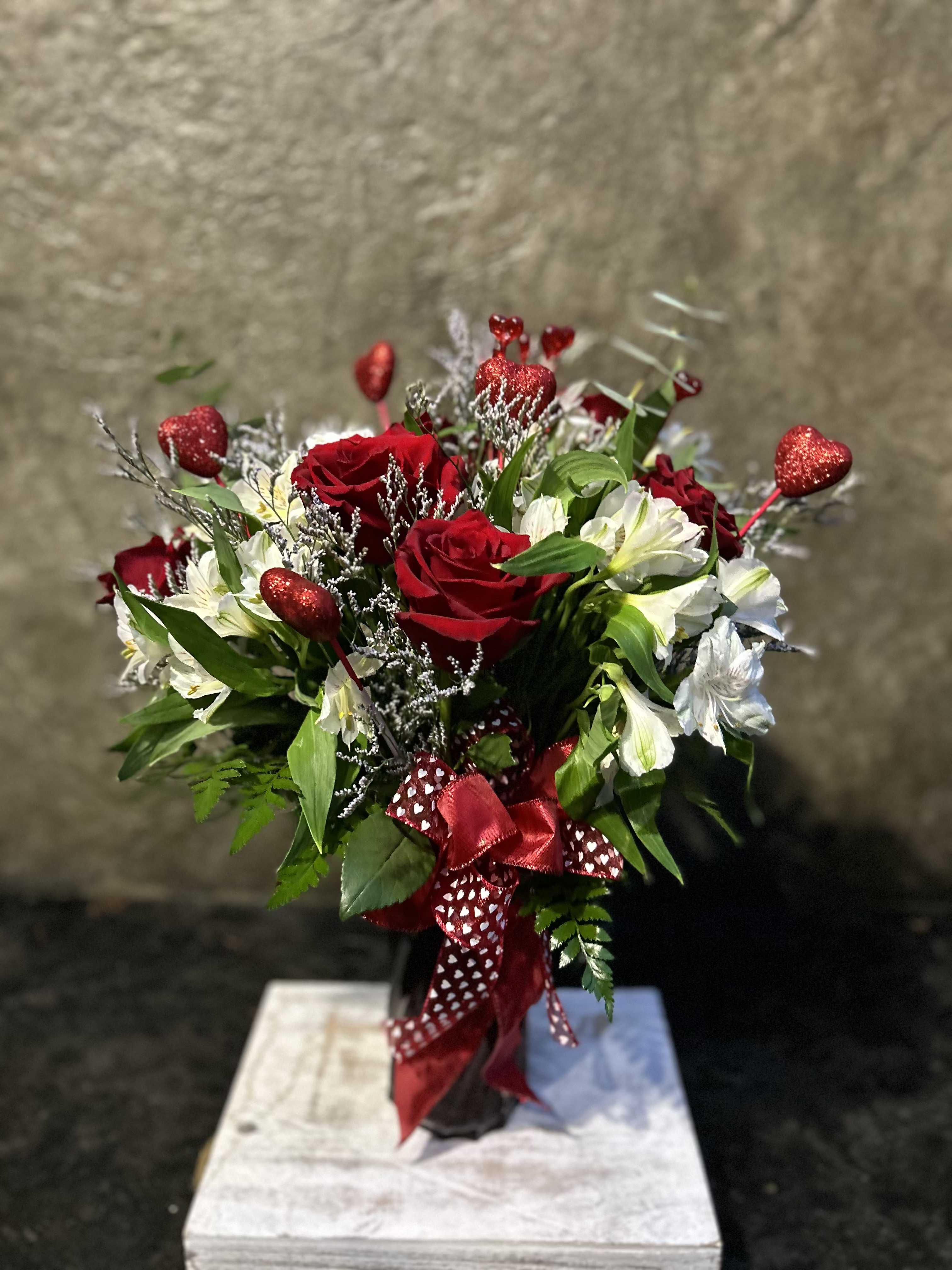 Heart Attack  - Red roses, white alstroemeria, limonium, eucalyptus, and lots of decorative hearts with red and white ribbon accent. Truly stunning!  *Reasonable Substitutions may be made due to floral availability. Will have same overall look and feel.