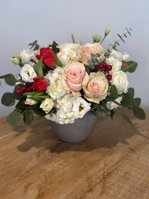 Kiss in Paris  - A spin on our #1 seller, the Touch of Grace Signature.  A whisper-quiet affirmation of love.  A combination of red, white, and pink florals to include roses, hydrangea and tulips in a classic concrete vessel.   One of our Valentine's Day specials! 