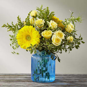 The FTD® Something Blue - FTD® proudly presents the Something Blue™ Bouquet. A rush of light and sky, this gorgeous sunlit flower bouquet is ready to make that perfect impression. Considered the happiest flower on earth, yellow gerbera daisies take center stage in this flower arrangement sharing the spotlight with pale yellow spray roses, yellow snapdragons, solidago, Queen Anne's Lace, and lush greens. Presented in a brilliant blue glass vase to make this gift boldly stand out from the rest, this flower bouquet is ready to create a winning thank you, thinking of you, engagement, or wedding gift.  GOOD bouquet is approx. 12"H x 12"W. BETTER bouquet is approx. 13"H x 13"W. BEST bouquet is approx. 13"H x 14"W.