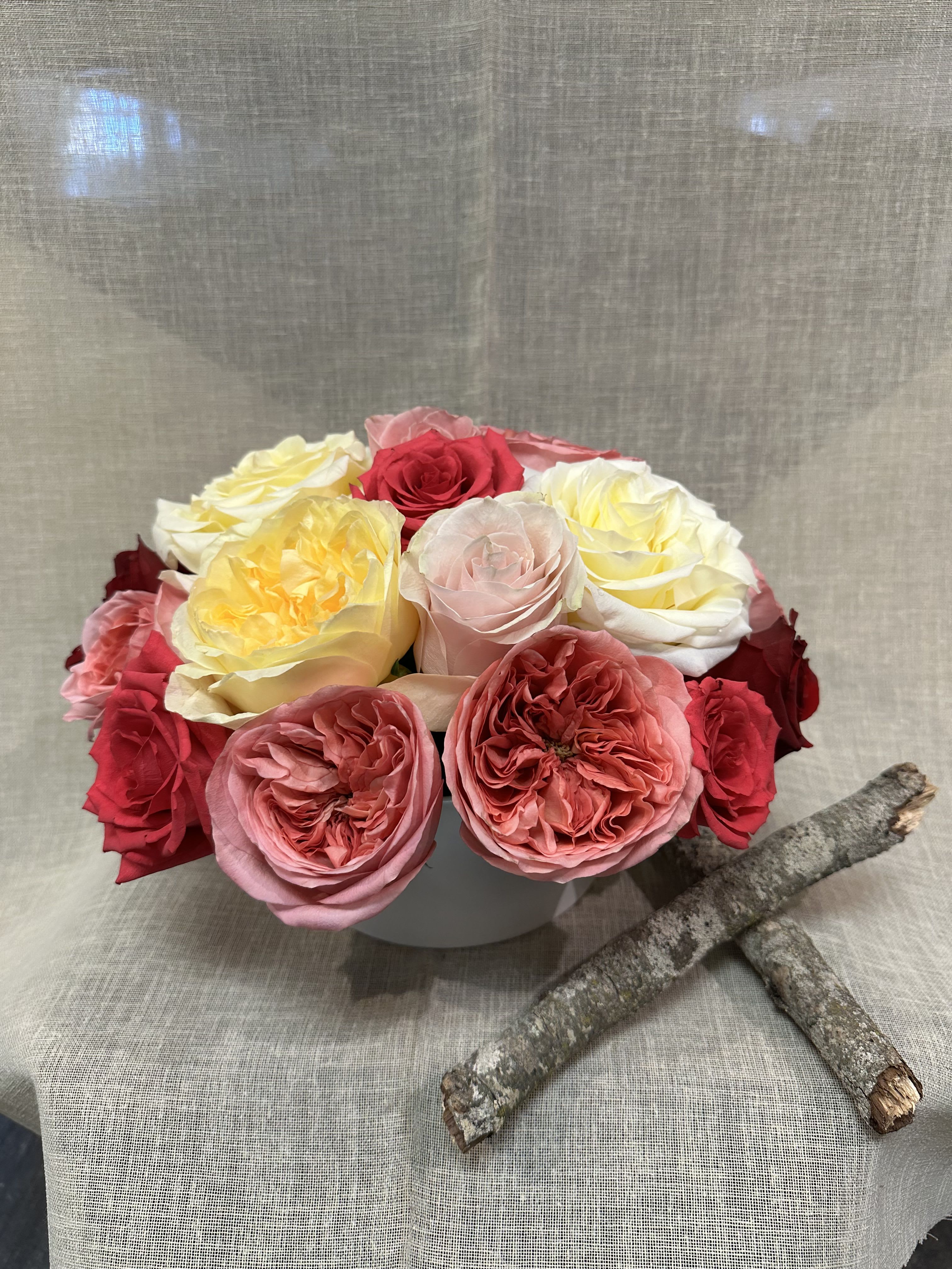 different shades of Garden Roses  - An exquisite variety of Garden roses. and regular roses in a white ceramic vase.