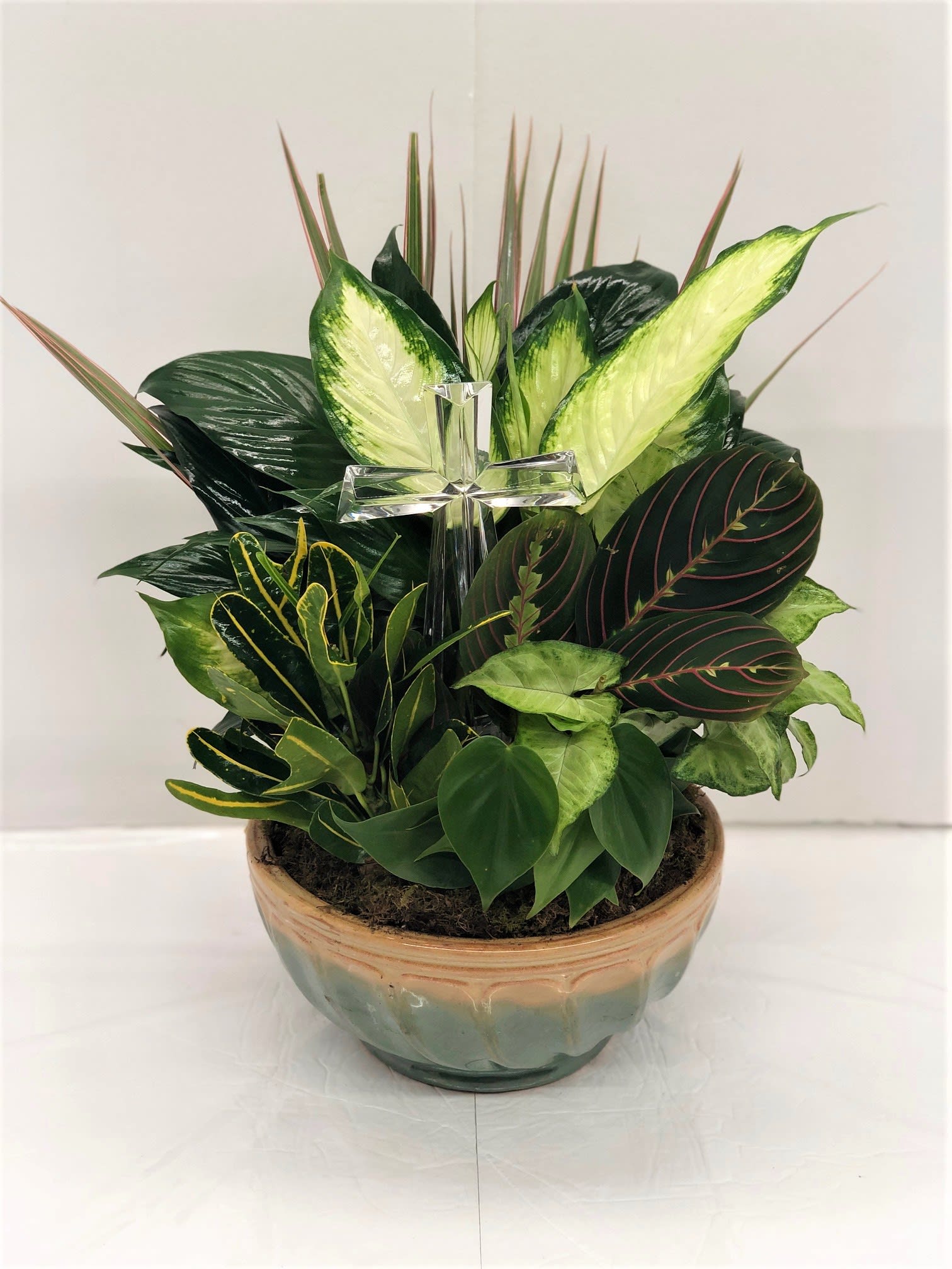 Dish Garden with a Cross - This dish garden has a mixture of green plants and a Peace Lily plant with a elegant crystal cross added for the family. (Crystal Cross Keepsake price has been added already $25.00)   FCF-0178