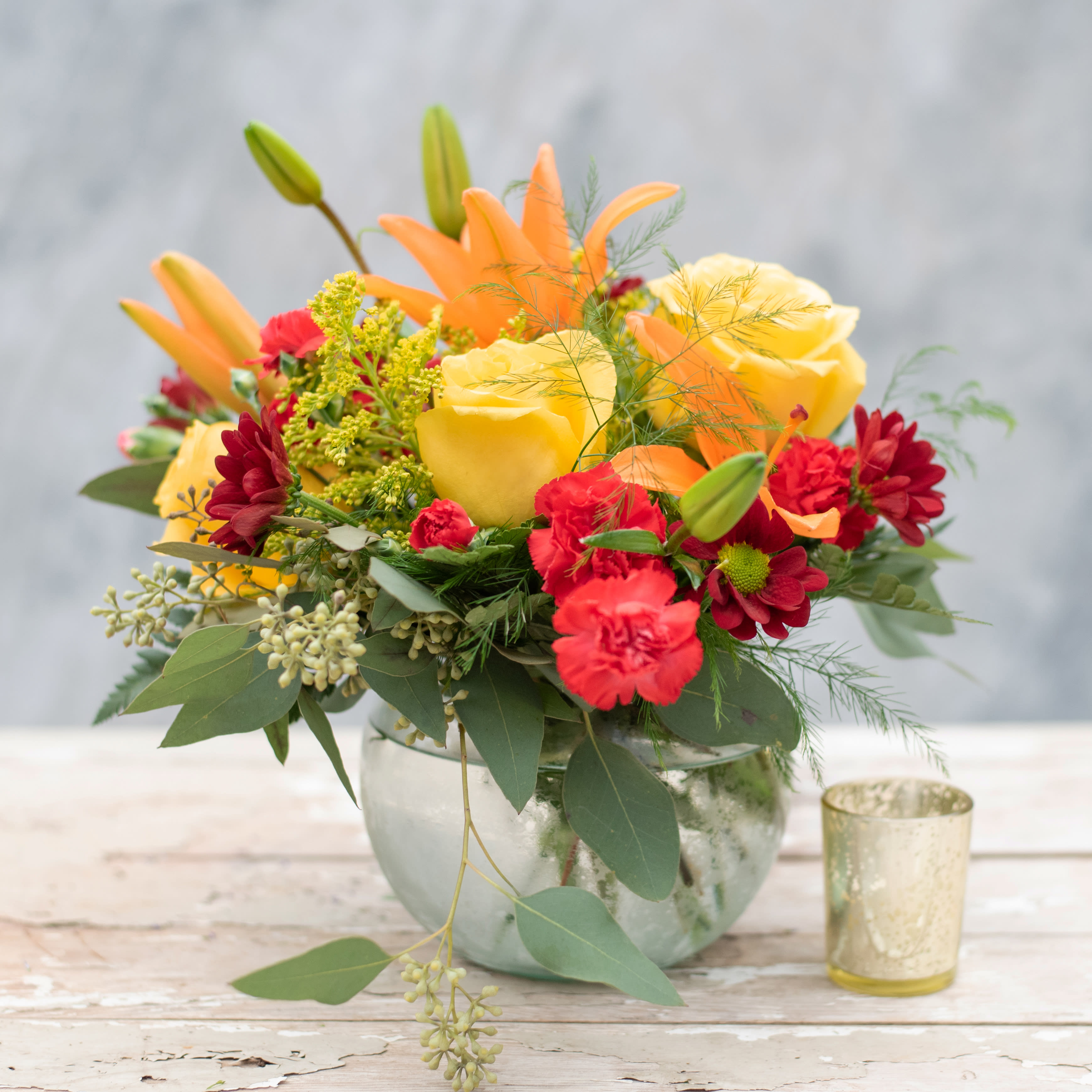 Spicey - Add a little spice to your coffee or end table or even your kitchen table, with this 5" bubble bowl overflowing with lilies, roses, chrysanthemums, and mini carnations in "Spicey" vibrant oranges, yellows and reds. 