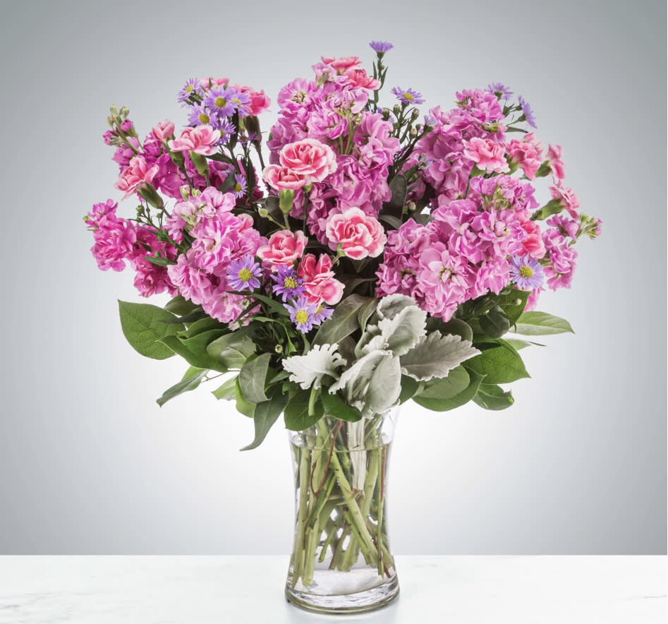 Uptown Girl - This arrangement is a pink and purple confection featuring sweet-smelling stock flowers and purple asters. A great gift for birthdays, women's day, or breast cancer awareness month.  Please Note: The bouquet pictured reflects our original design for this product. While we always try to follow the color palette, we may replace stems to deliver the freshest bouquet possible, and we may sometimes need to use a different vase.  