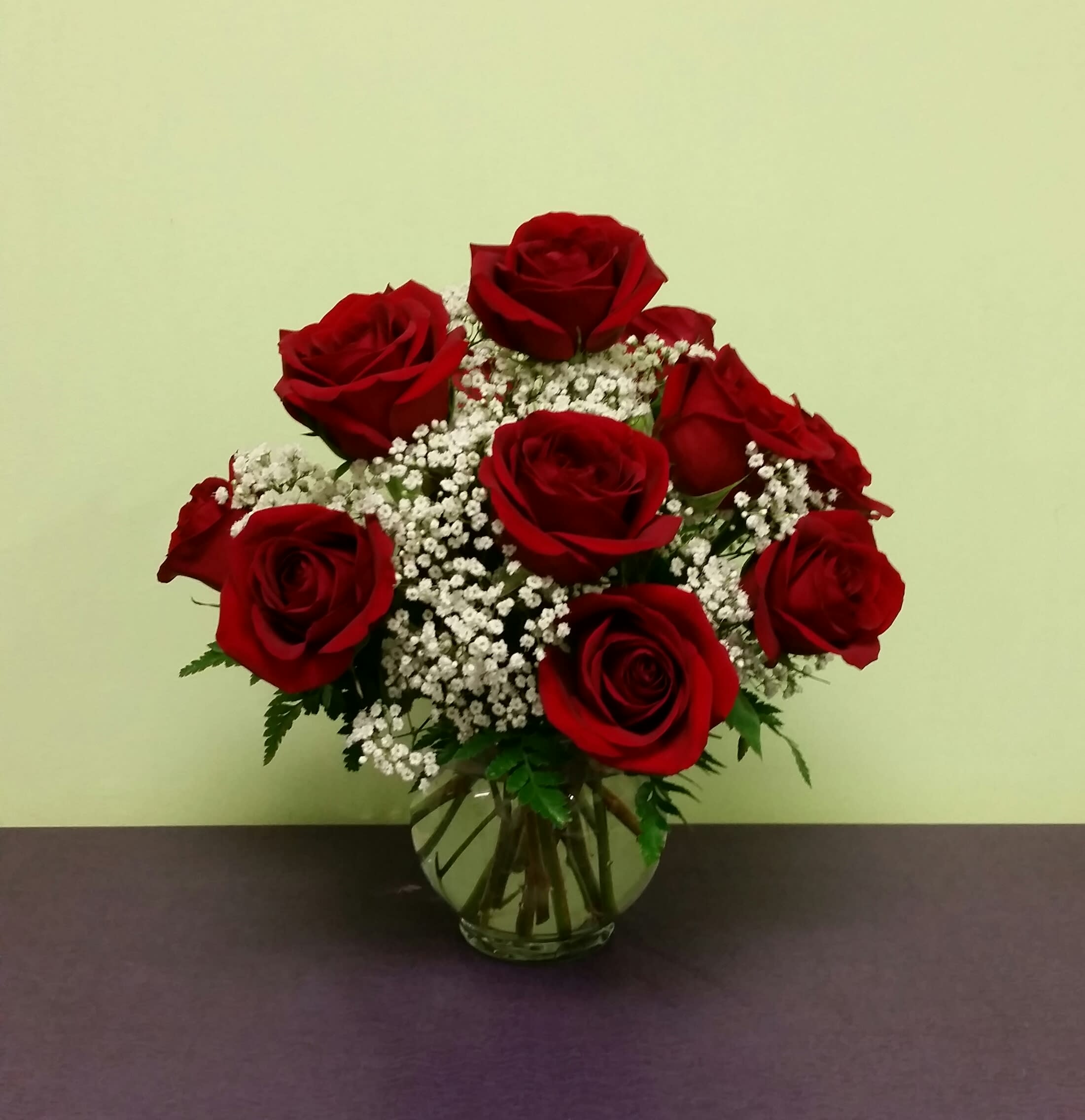 Red Rose Bowl - This arrangement includes a dozen red roses with greens and baby's breath, beautifully designed in a small fishbowl vase. It can fit on any table or desk. A truly perfect way to send some love and show some romance!