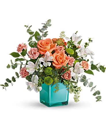Teleflora's Sunset Splash Bouquet - Inspired by the warm peach skies and crystal blue waters of a tropical sunset, this fun-filled rose bouquet adds a splash of happiness to any occasion! This delightful arrangement features peach roses, white alstroemeria, peach miniature carnations, green button spray chrysanthemums, spiral eucalyptus, seeded eucalyptus, oregonia, and lemon leaf. Delivered in an Aqua Color Splash Cube.