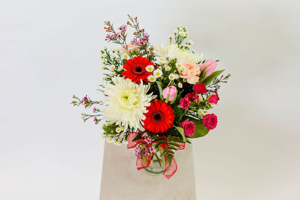 Jenny in love - Isn't love grand?  This bouquet features a beautiful mix of reds, pinks and whites to create a special dispay of your affection.  Size of bouquet is great for a kitchen table, island or coffee table.  Please read substitution policy.
