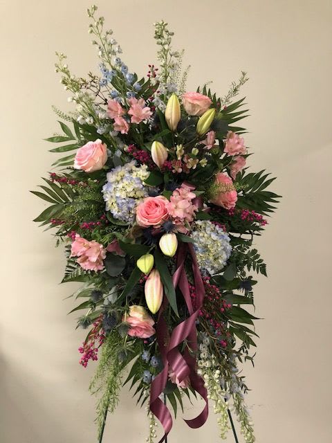 Sincere Condolences - Send your condolences with this soft colored standing spray featuring lilies, hydrangea, roses, delphinium and other in season blooms... Please Note: Each design is custom made and filled to value. We only use fresh product to ensure top quality so new orders are subject to substitutions.