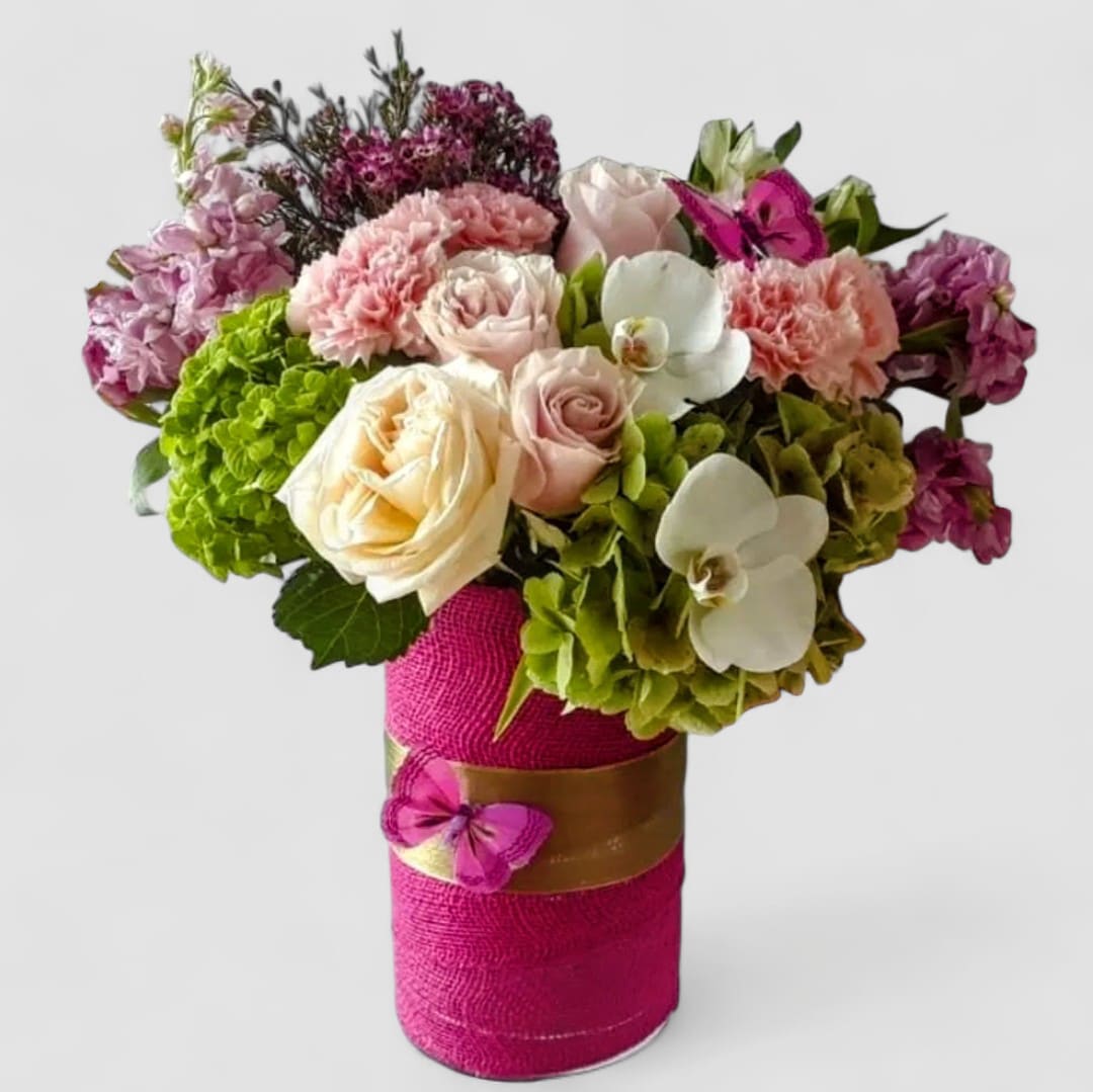 Beautiful Pink Blossom Bouquet Designer's Choice - Send this beauty today to show them how much you care with it's lovely mixed pink and white blossoms of the day roses orchids hydrangeas and more arranged in a tall modern glass cylinder vase wrapped in pretty hot pink jute ribbon adorned with a sparkly butterfly. Beautiful and perfect to send today for every reason to make her smile. Always made extra special and unique each time. Send her happiness.