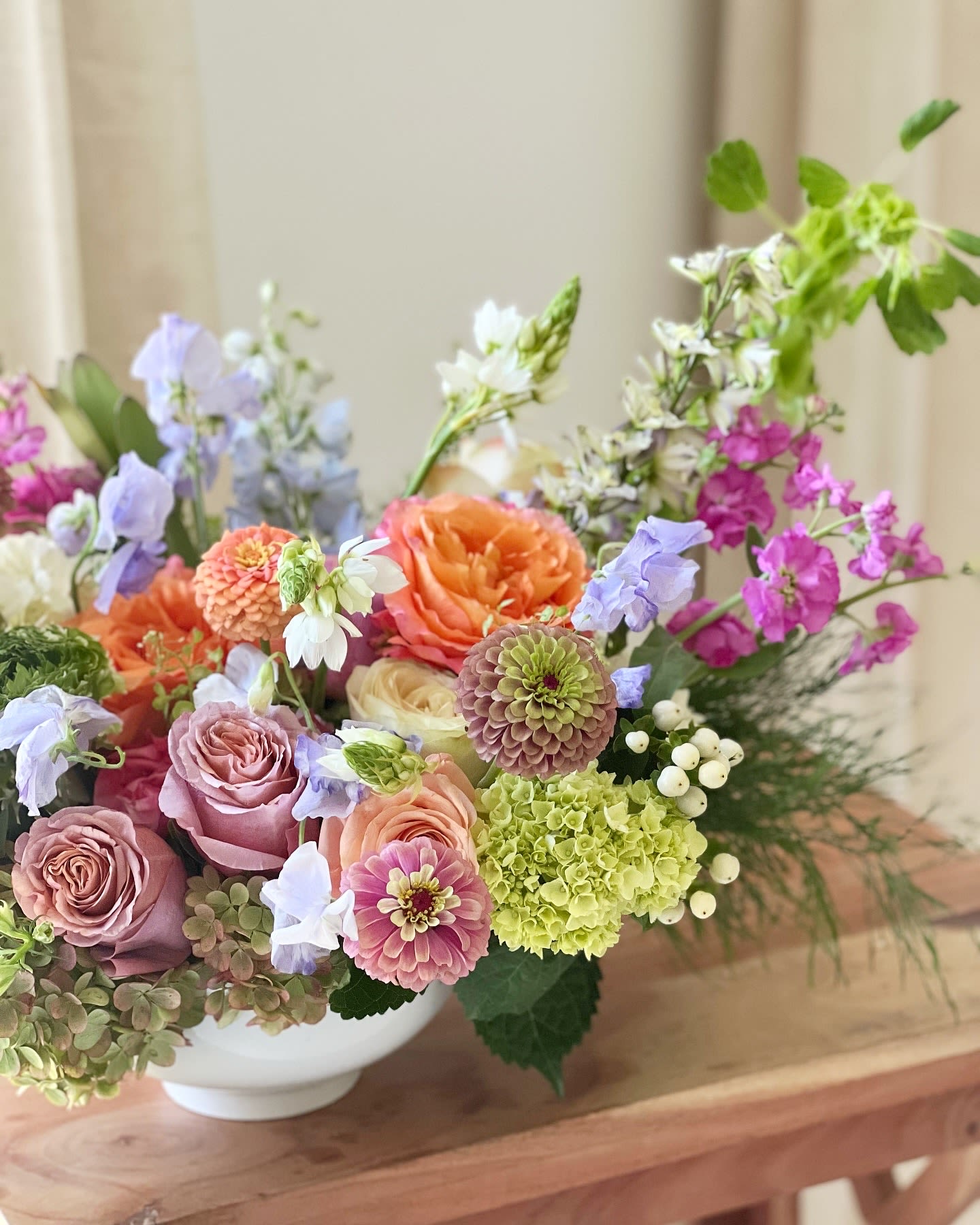 The Flower Bowl  - Send this Lush Garden-Style arrangement designed in a white ceramic bowl. Featuring garden roses, and other seasonal fresh premium flowers. (Designer's choice colors)   Pictured is our standard size. 