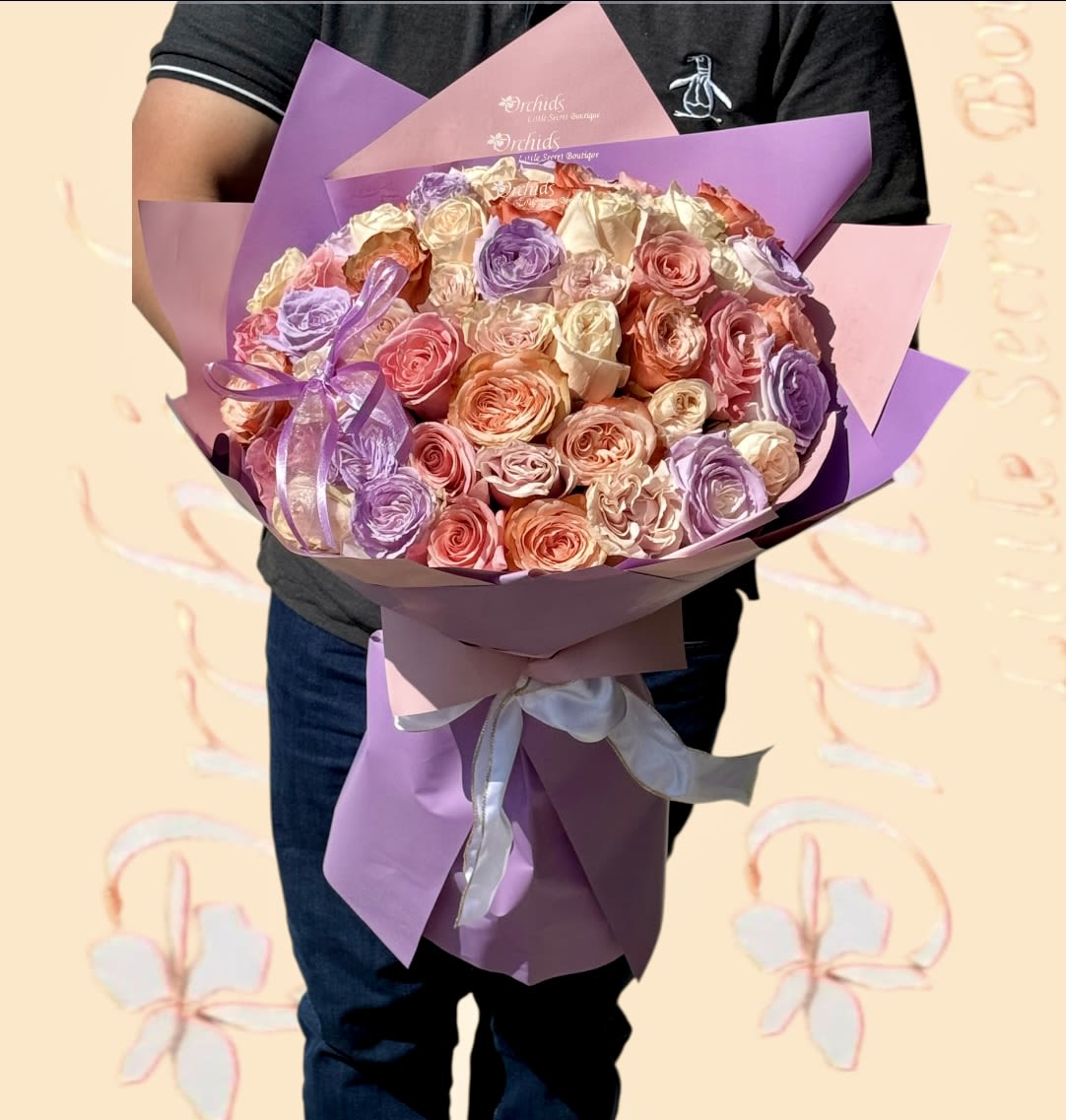 50/100  Peach Candle Light Lavender &amp; Pink Garden  Roses Mix Hand Wrapped Bouquet - Impress your recipient with this stunning, hand-wrapped bouquet of 50 or 100 exquisite garden roses, featuring delightful peach, pink, lavender, and candlelight hues. These blooms are artfully wrapped in lavender paper and adorned with a peach ribbon. Ideal for Valentine’s Day, 50th wedding anniversaries, a special occasion, just because, or golden birthdays.   