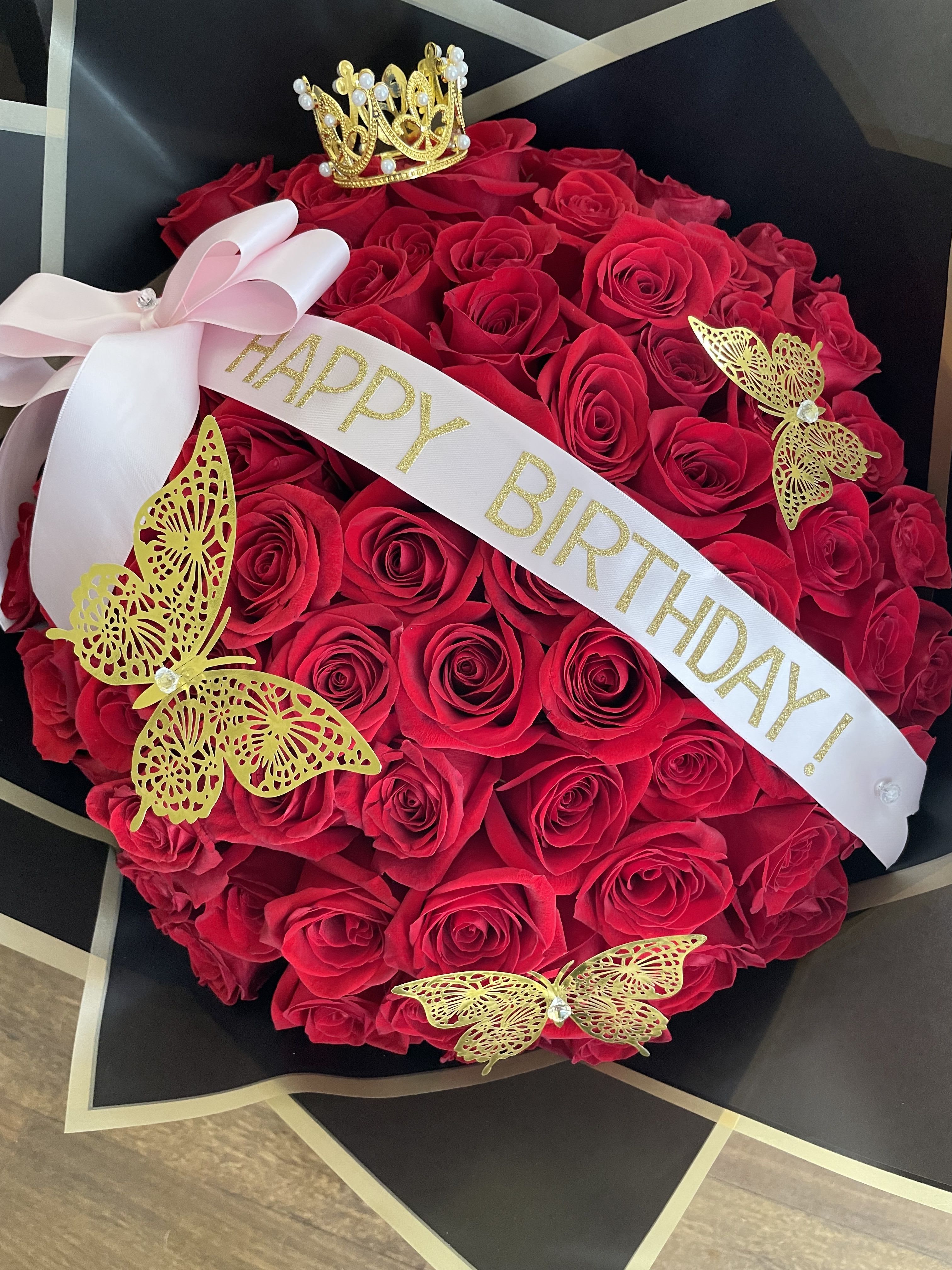  Buchon Bouquet -  red roses wrapped in black paper with sparkly butterflies, a crown and custom ribbon. for any occasion. Standard three dozen, Deluxe four dozen, Premium six dozen, picture showed premium 