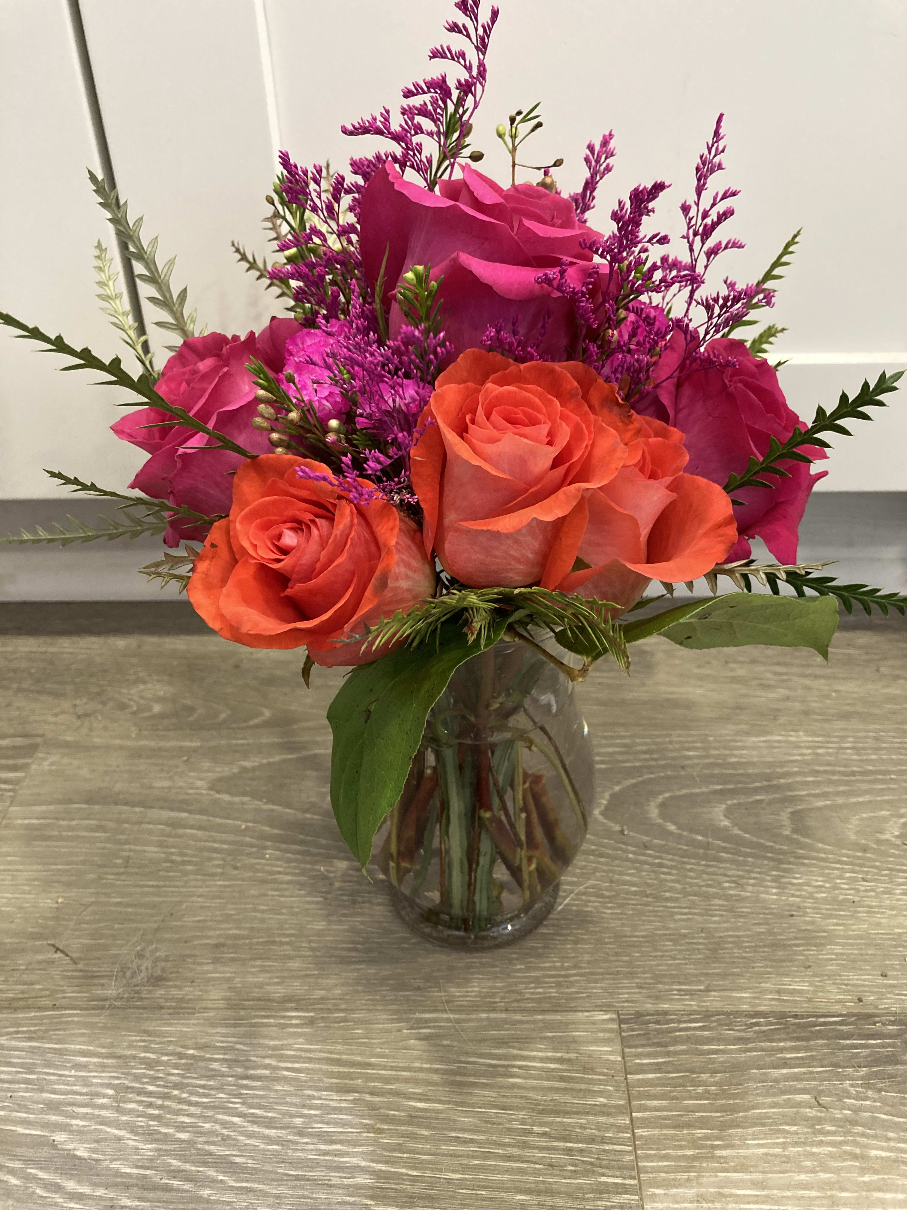 Bright and Beautiful  - Small vase of roses and pink filler with greens.