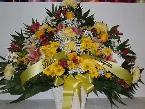 TB38 Traditional Basket - A mixture of yellow daisies, yellow roses, yellow fuji mums, red alstromaria, shocking lilies, baby's breath, greens and yellow bow  Banner - $15.00 + extra  Substitutions may apply due to flower availability