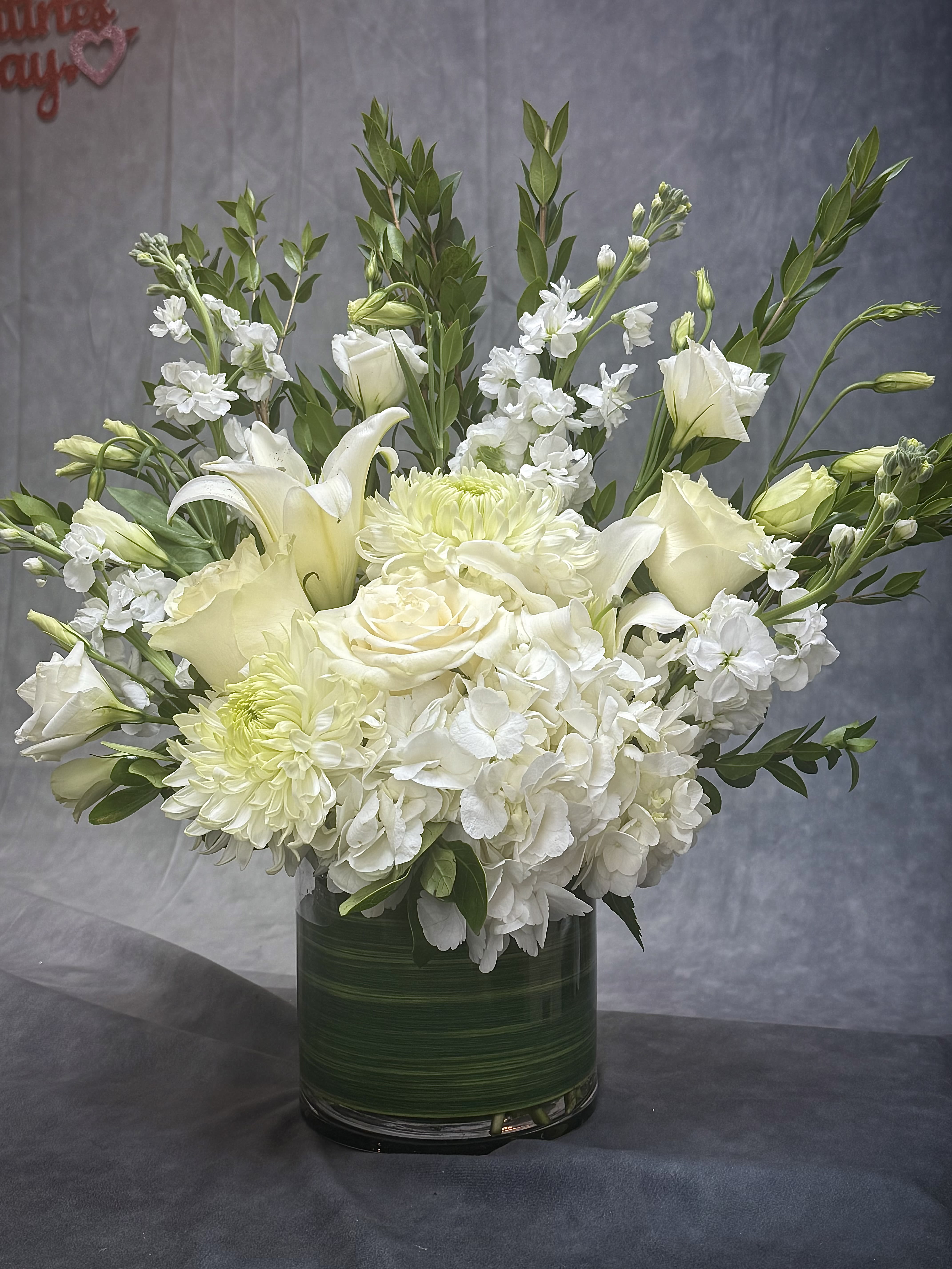 Heavenly Grace Vase - Soft whites and fresh greens come together in this airy arrangement, symbolizing purity, sympathy, and heartfelt remembrance.
