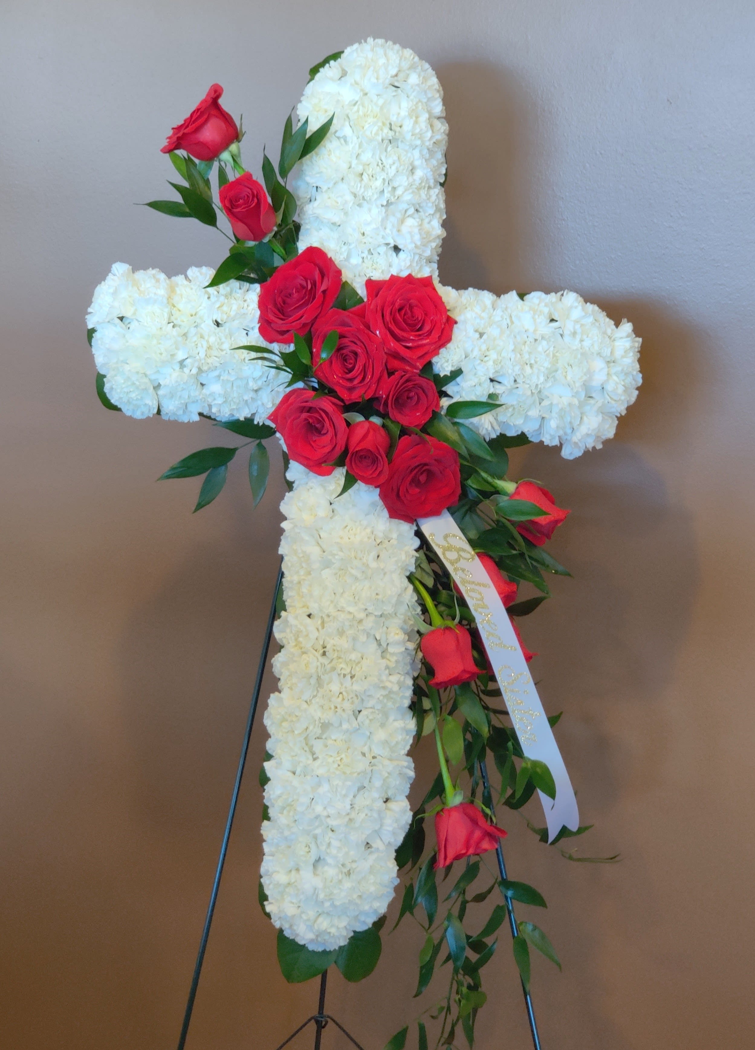 White Cross Standing Spray ~ Flower A Day - A traditional Standing Spray design in a cross shape, on an easel, featuring red roses, white carnations, and assorted greens. 