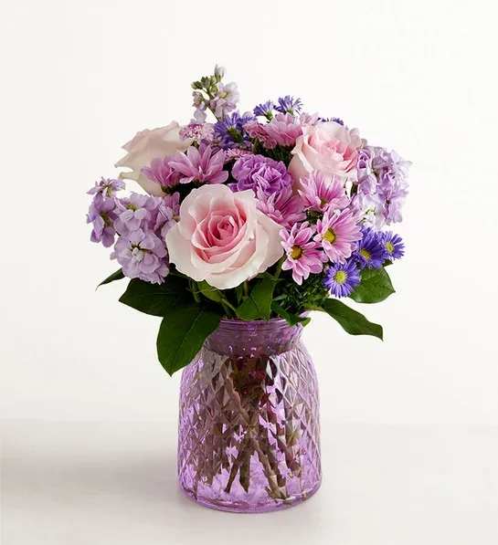Daydream bouquet 192115 - Just like a daydream. Our delightful lavender bouquet is gathered with accents of pink and lush greenery in an embossed lavender vase that complements the delicate beauty of the blooms.