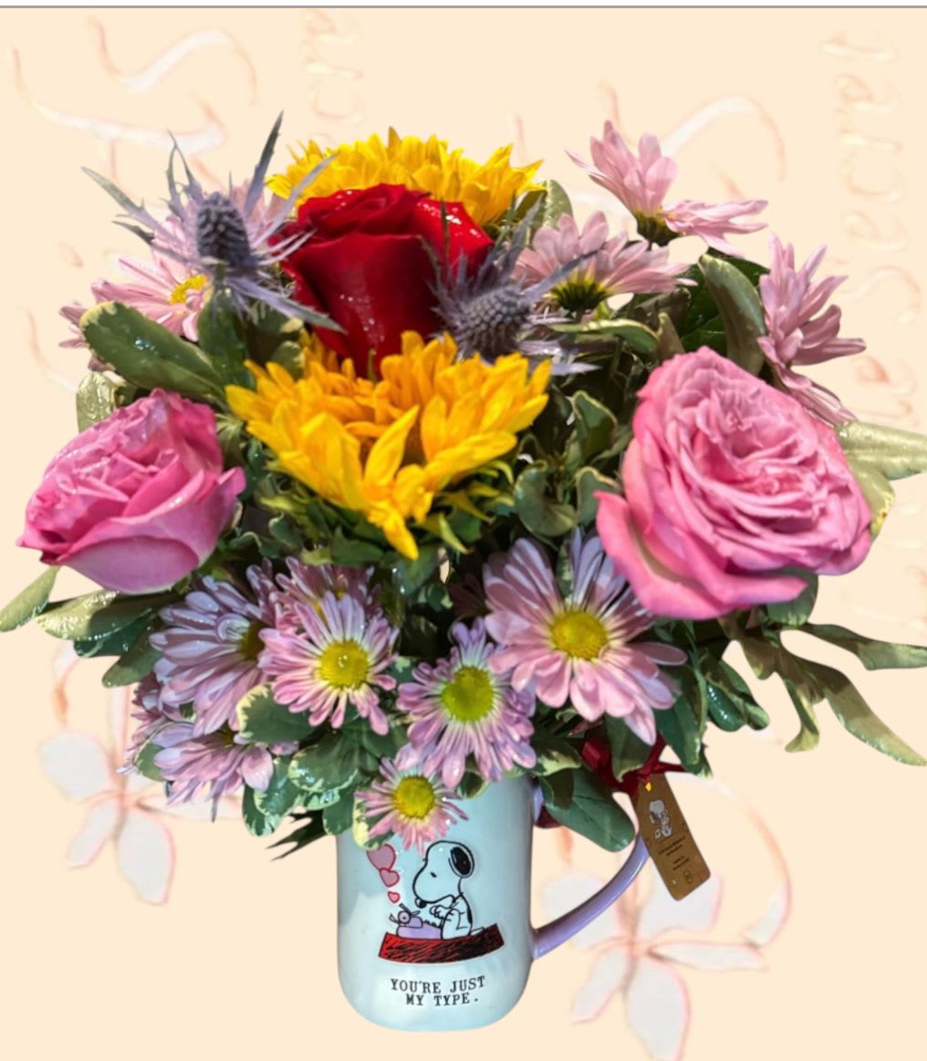 Sunflowers Lavender Red Roses Arrangement Snoopy Valentine’s Mug “You’re Just My Type  - Arrangement measures approximately 15"H  Introducing a delightful Snoopy Valentine's mug, crafted by Rae Dunn, designed to bring a smile. This charming mug features "You're just my type" Snoopy typewriting and a heart-shaped handle, adorned with vibrant yellow sunflowers, exquisite red and lavender roses, accented with lavender daisies. Reusable after proper cleaning, this mug offers daily enjoyment. Perfect for morning coffee or afternoon tea, it makes a thoughtful gift for Valentine's Day, a loved one, a secret crush, or simply as a way to express appreciation and show someone you care!