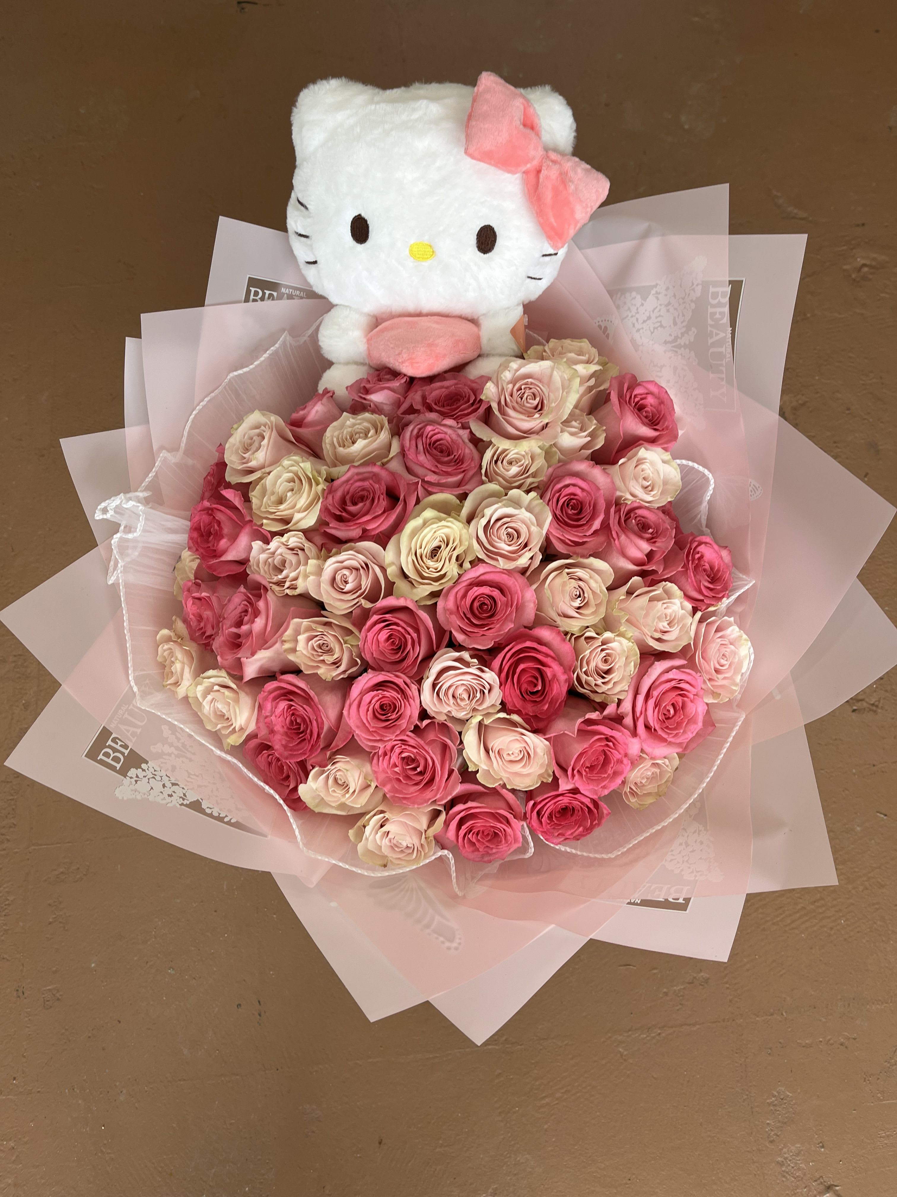 Hello Blossom - A sweet and whimsical bouquet of soft pink roses crowned with a cuddly Hello Kitty plush. It blends innocence, affection, and charm—perfect for celebrating love, friendship, or a heartfelt surprise that feels both playful and romantic.  (Picture is 50 roses) 
