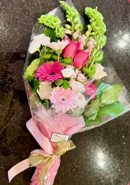 Wrapped In Love - A beautifully wrapped bouquet of flowers in all shades of pink and green tied with a pretty satin ribbon.  This is a sweet expression of your love. Please note that this choice does not come in a vase. The bouquet will be wrapped with a water source to ensure freshness. Upon arrival the recipient will need to place the bouquet in a vase. 