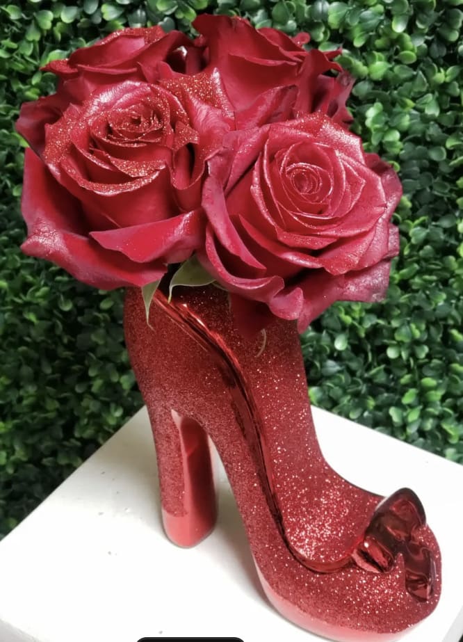 Dainty "Sparking Shoe Lovers" Vase Arrangement with Sparkle Red Roses - This Dainty "Shoe Lovers" Vase Arrangement includes 8 to 10 large bloom fresh cut Red Sparkle Rose's in a gorgeous Red Blinged Out  ceramic High Heel Shoe Vase (vase measures  1.5" opening X 6.75" high )  including plant food preservative water source for extended life 