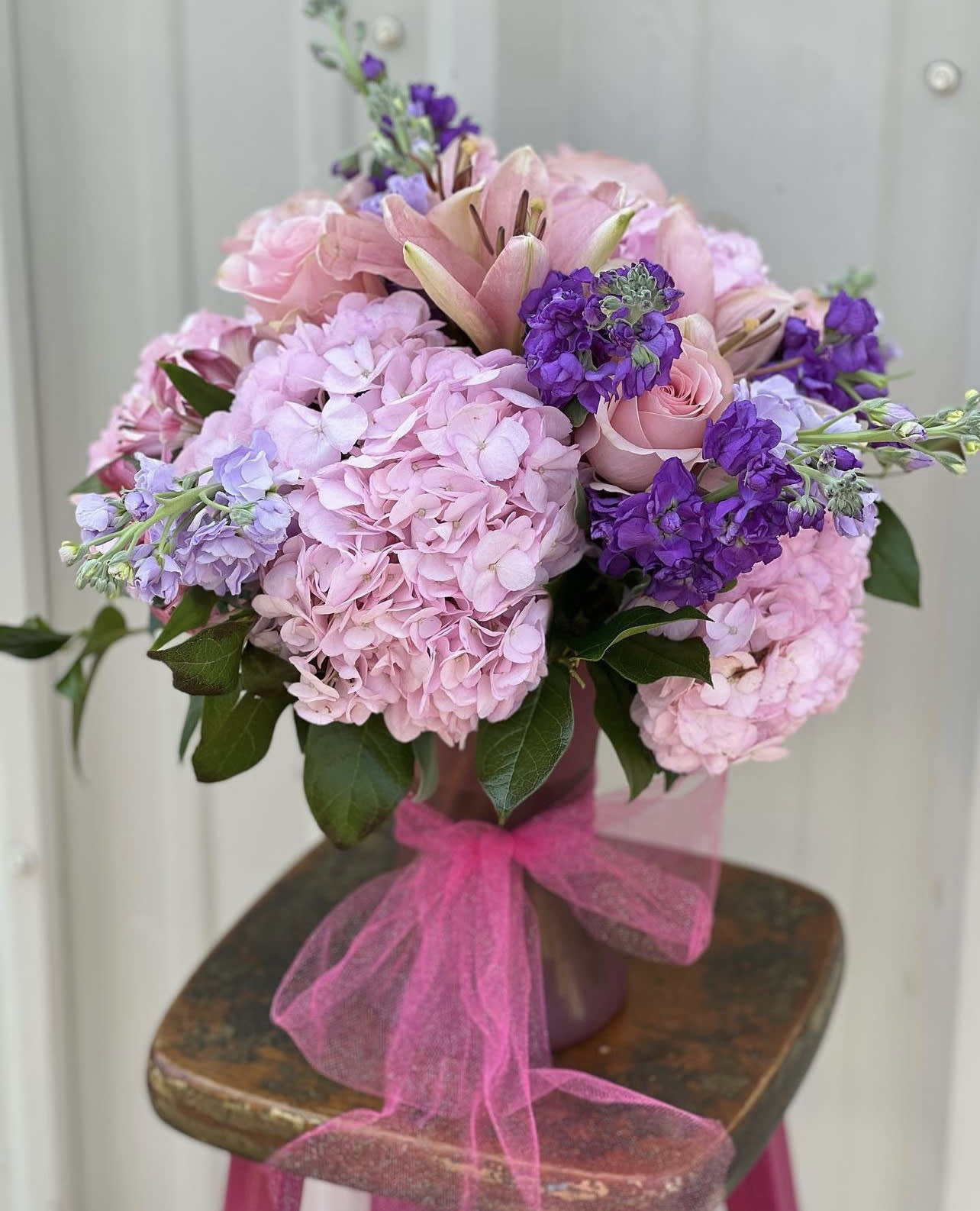 Pastel Blooms in Pink &amp; Purple Vase Arrangement  - Designers Choice of Pastel Pink &amp; Purple Tones of an Array of Fresh Cut Florals to include Hydrangeas arranged in a Glass Vase with Bow (vase size and shape vary)