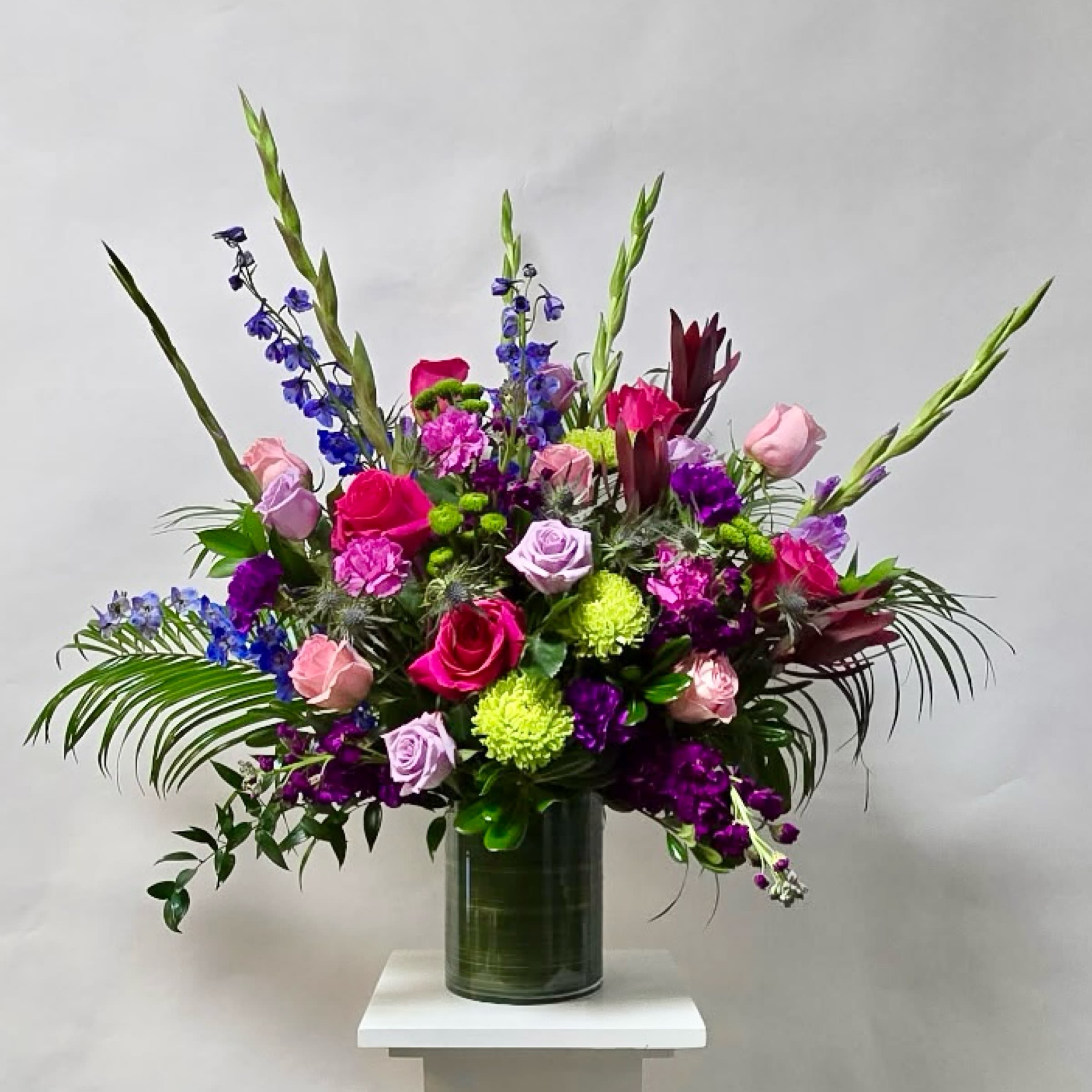 Joyful Garden - This Vase Arrangement Includes Lavender Gladiolas, Hot Pink Roses, Lavender Roses, Light Pink Roses, Green Fuji Mums, Purple Stock, Green Buttons, Safari Sunset, Purple Carnations, Pink Carnations, Blue Delphinium and Blue Thistle. Or as Similar as Possible. 