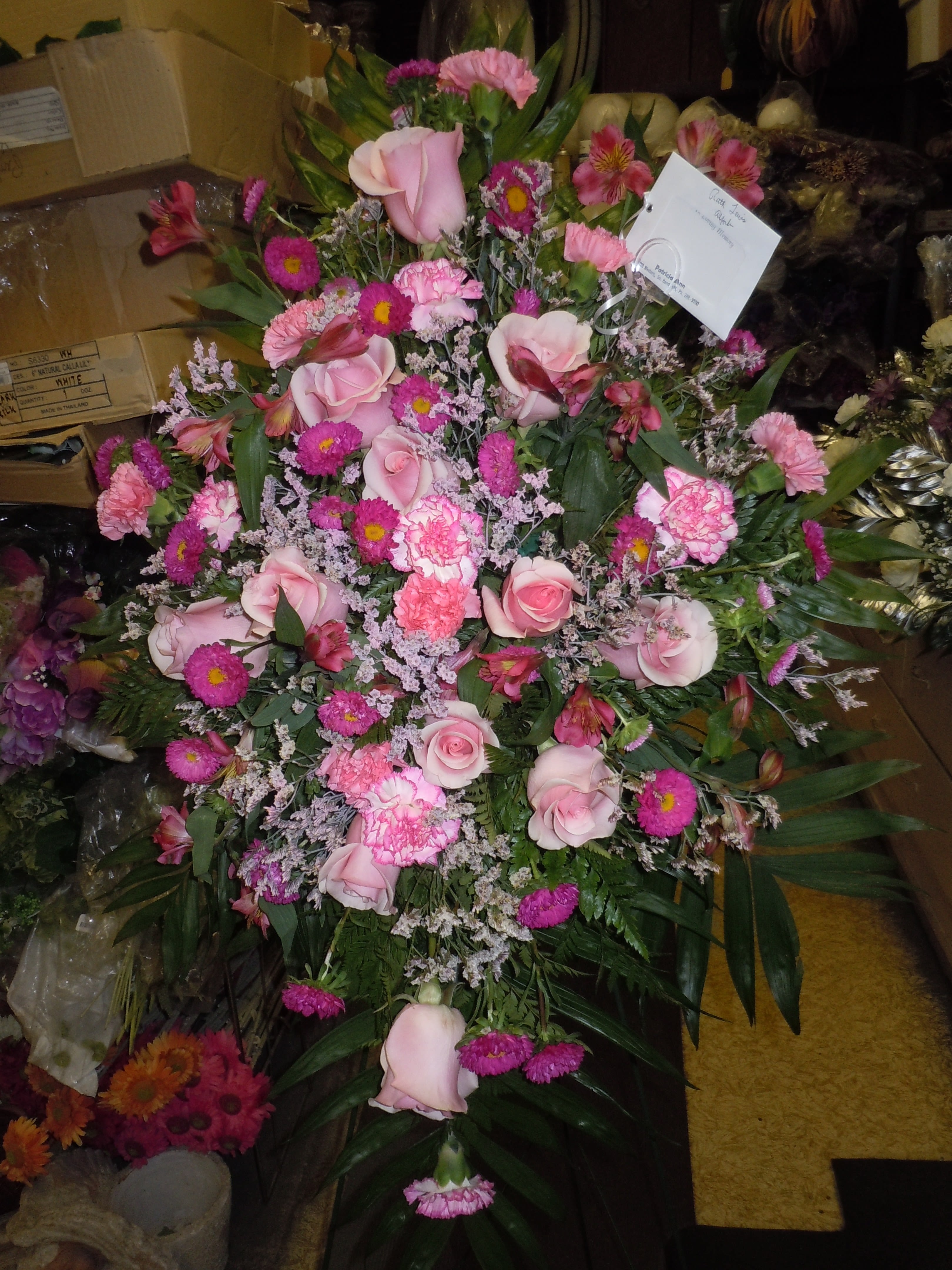 SP8 - A mixture of pink carnations, pink tipped carnations, blue mist tinted pink, hot pink aster, pink alstromaria, pink roses, lavender fuji mums, baby's breath, greens   Banner - $15.00 + extra  Substitutions may apply due to flower availability