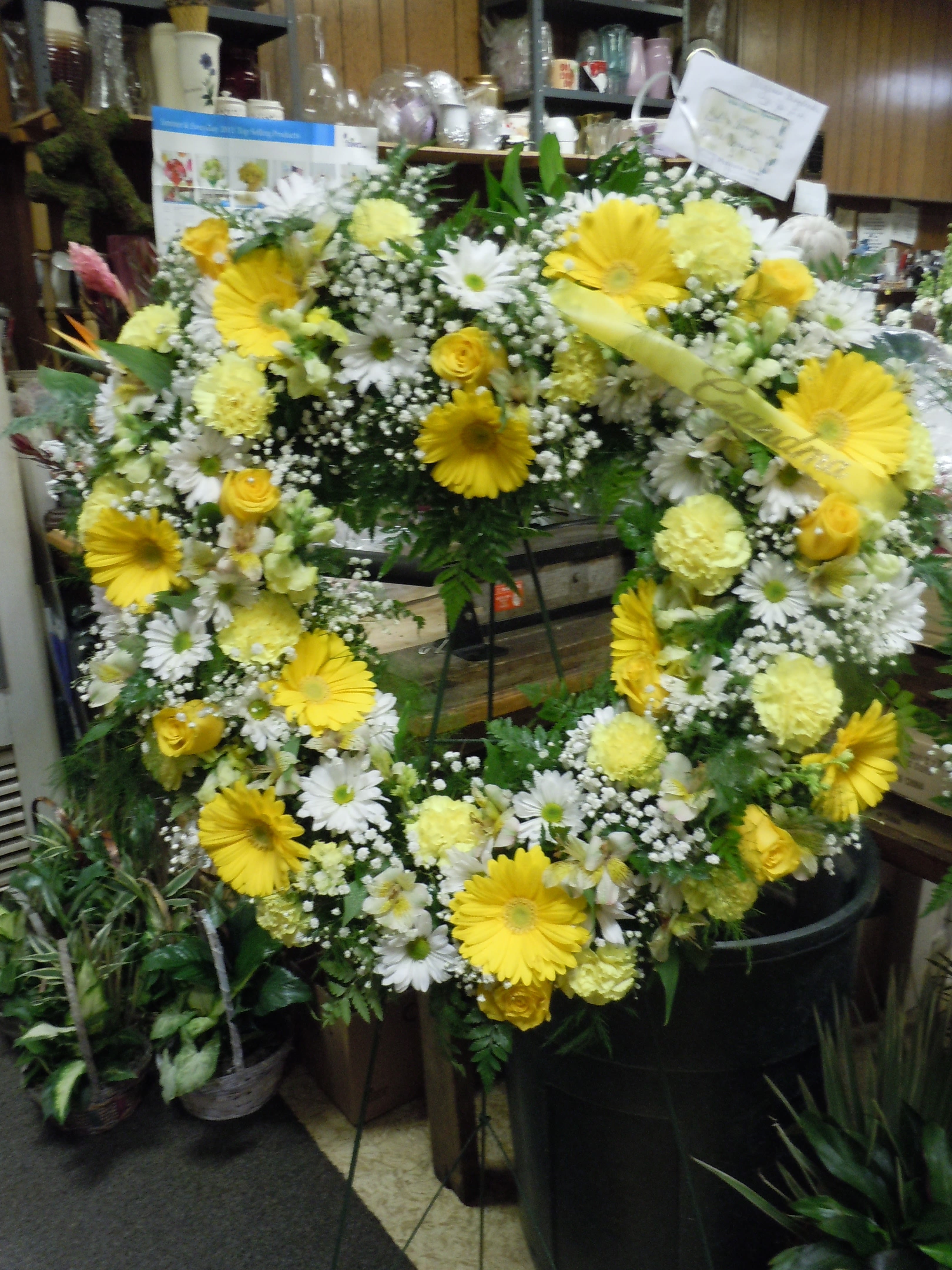 SP18 Standing Spray - An open heart with a mixture of gerbera daisies, white daisies, roses, carnations, baby's breath, greens.  Banner - $15.00 + extra  Substitutions may apply due to flower availability