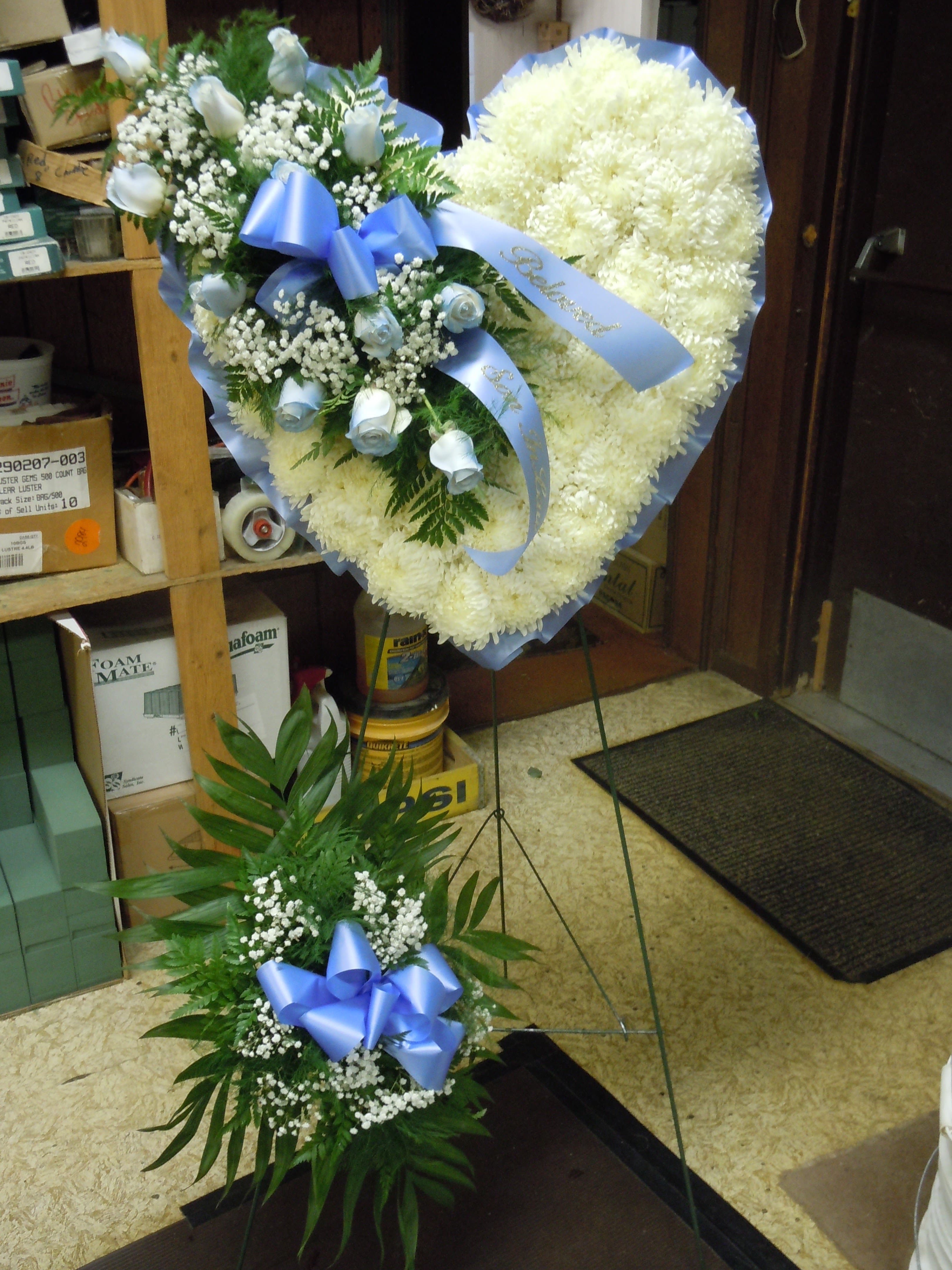 SP23 Standing Spray - Heart shape with a  mixture of fuji mums, white roses, baby's breath and greens.   Banner - $15.00 + extra  Substitutions may apply due to flower availability