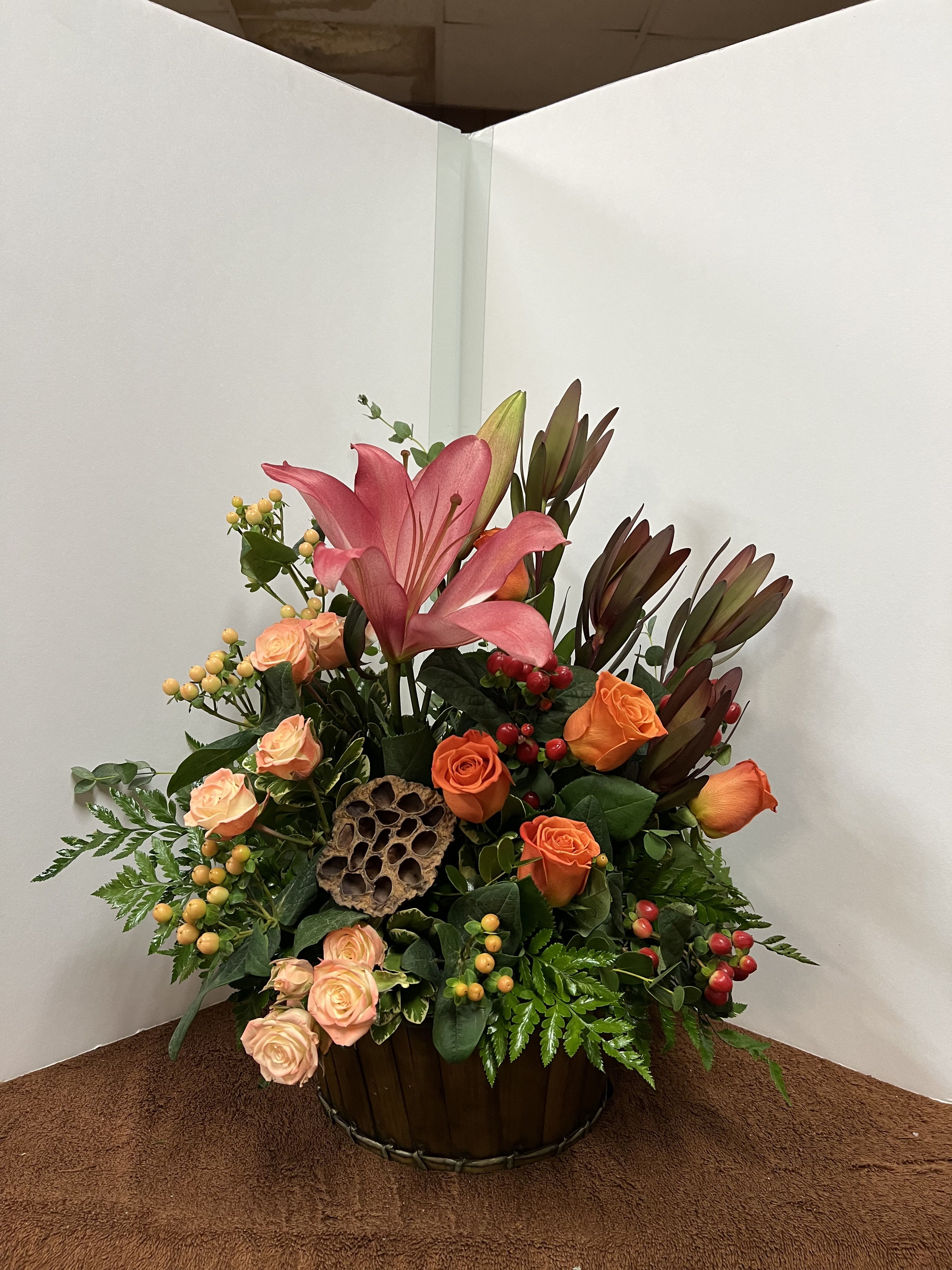 Rustic Country - A mix of sunset safari, orange roses, light orange spray roses, pods, lilies, hypericum, leather leaf, myrtle.