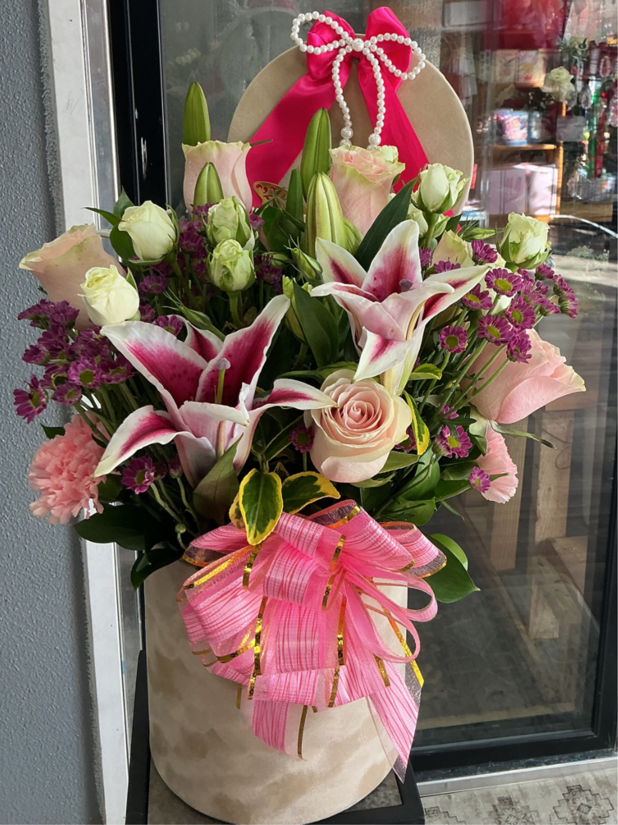 Pink bow  - This cute arrengment is perfect to show love is made of lillies , light pink roses ,pink carnation ,greens ,and mini white roses to add the extra special comes with many bows 