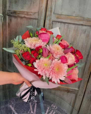 Valentine's Wrapped Bouquet - Our Valentine's Day wrapped bouquet is mix of red, white and pink flowers accented with greens.